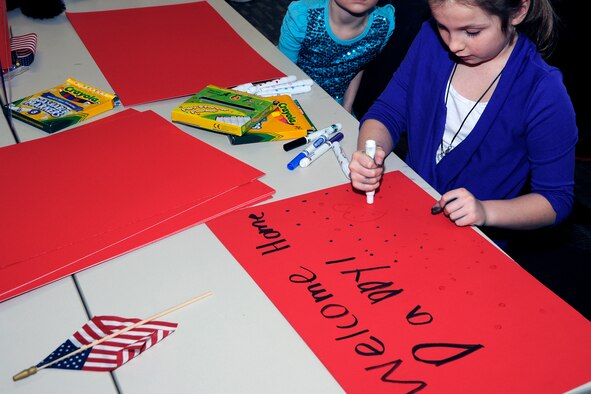 Hailey Froese, daughter of TSgt Andrew and Jennifer Froese, creates a sign on March 2, 2014, at Selfridge Air National Guard Base, Mich., to welcome home her father after his six-month deployment in support of Operation Enduring Freedom. (U.S. Air National Guard photo by John S. Swanson / Released)