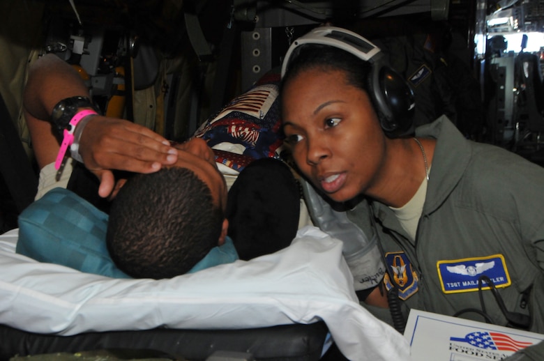 U.S. Air Force Tech. Sgt. Maila Butler with the U.S. Air Force Reserve, assigned to the 775th Expeditionary Aeromedical Evacuation Flight, Joint Base Andrews, Md., checks on the well-being of a wounded soldier aboard a KC-135 Stratotanker assigned to the 128th Air Refueling Wing, Milwaukee, while being transported to another medical facility for further treatment Jan. 13, 2014. Butler is part of a five-person EAEF team aboard the KC-135 demonstrating total force integration. The aeromedical evacuation mission transported wounded service members from all branches of the military from one location to the next. (U.S. Air National Guard photo by Staff Sgt. Jeremy Wilson/Released)