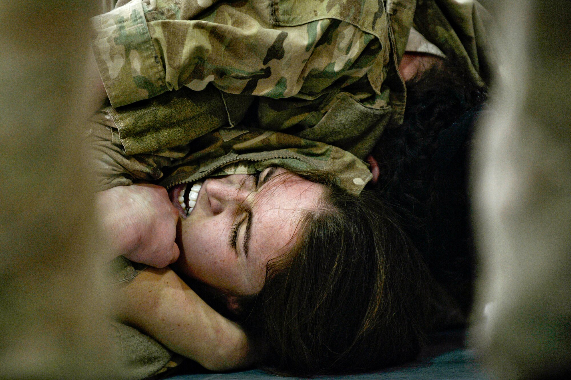 U.S. Air Force 1st Lt. Kelly Schuetz participates in the 2nd Annual Jiu-Jitsu tournament at Bagram Airfield, Afghanistan, March 1, 2014. Jiu-Jitsu is a martial art with a foundation of self-defense and the tournament had approximately 85 participants. (U.S. Air Force photo by Senior Airman Kayla Newman/Released) (Image was lightened and cropped to emphasize subjects.)