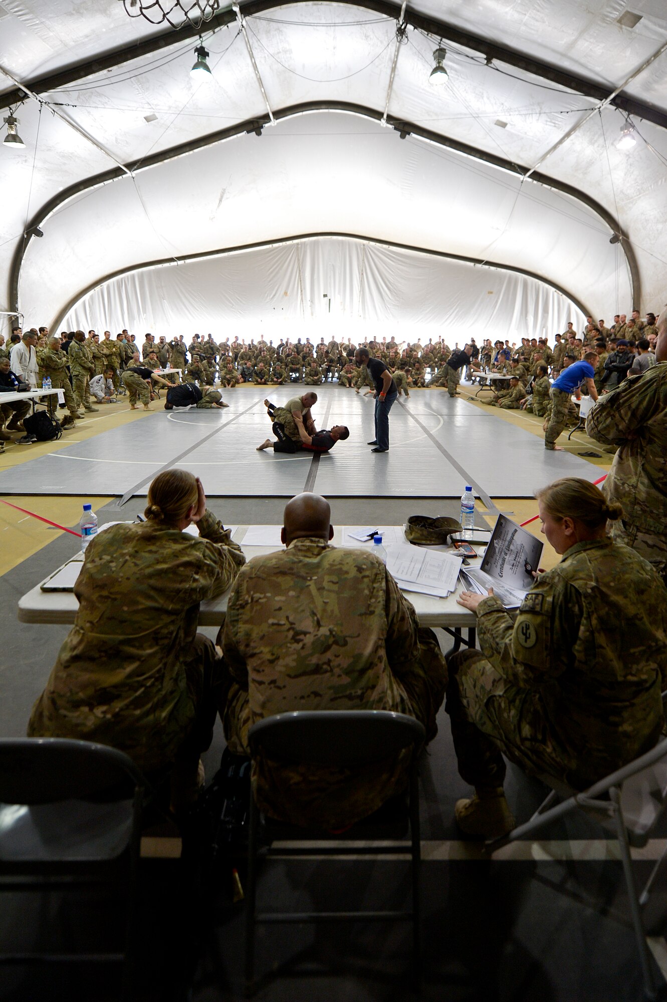 The Jiu-Jitsu club hosted the 2nd annual tournament at Bagram Airfield, Afghanistan, March 1, 2014. Jiu-Jitsu is a martial art with a foundation of self-defense and the tournament had approximately 85 participants. (U.S. Air Force photo by Senior Airman Kayla Newman/Released) (Image was lightened and cropped to emphasize subjects.)
