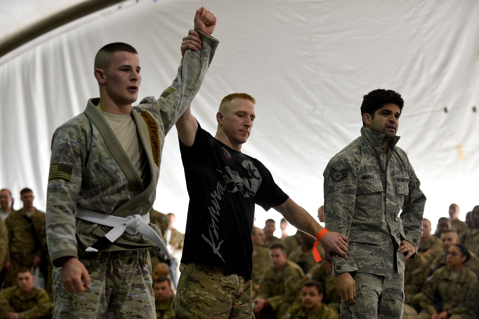 U.S. Air Force Master Sgt. Ryan Blumberg, 455th Expeditionary Force Support Squadron manpower analyst, signals a winner of a Jiu-Jitsu match during a tournament at Bagram Airfield, Afghanistan, March 1, 2014. Jiu-Jitsu is a martial art with a foundation of self-defense and the tournament had approximately 85 participants. (U.S. Air Force photo by Senior Airman Kayla Newman/Released) (Image was lightened and cropped to emphasize subjects.)