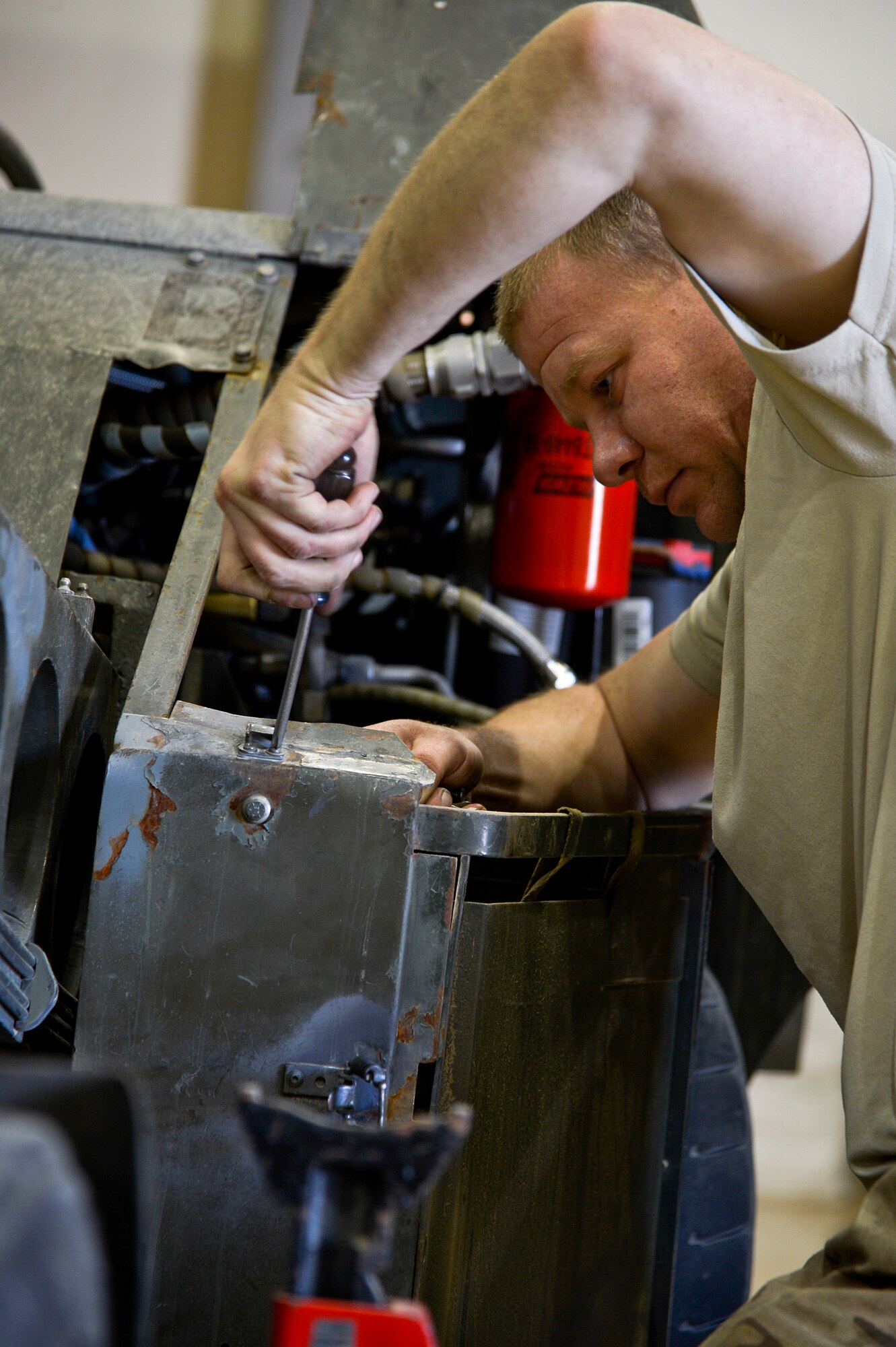 U.S. Air Force Senior Airman John Little, 455th Expeditionary Maintenance Squadron AGE technician, works on a bomb lift at Bagram Airfield, Afghanistan, Feb. 28, 2014. AGE maintains, services and performs operation checks on the ground equipment used on the aircraft at Bagram. (U.S. Air Force photo by Senior Airman Kayla Newman/Released)
