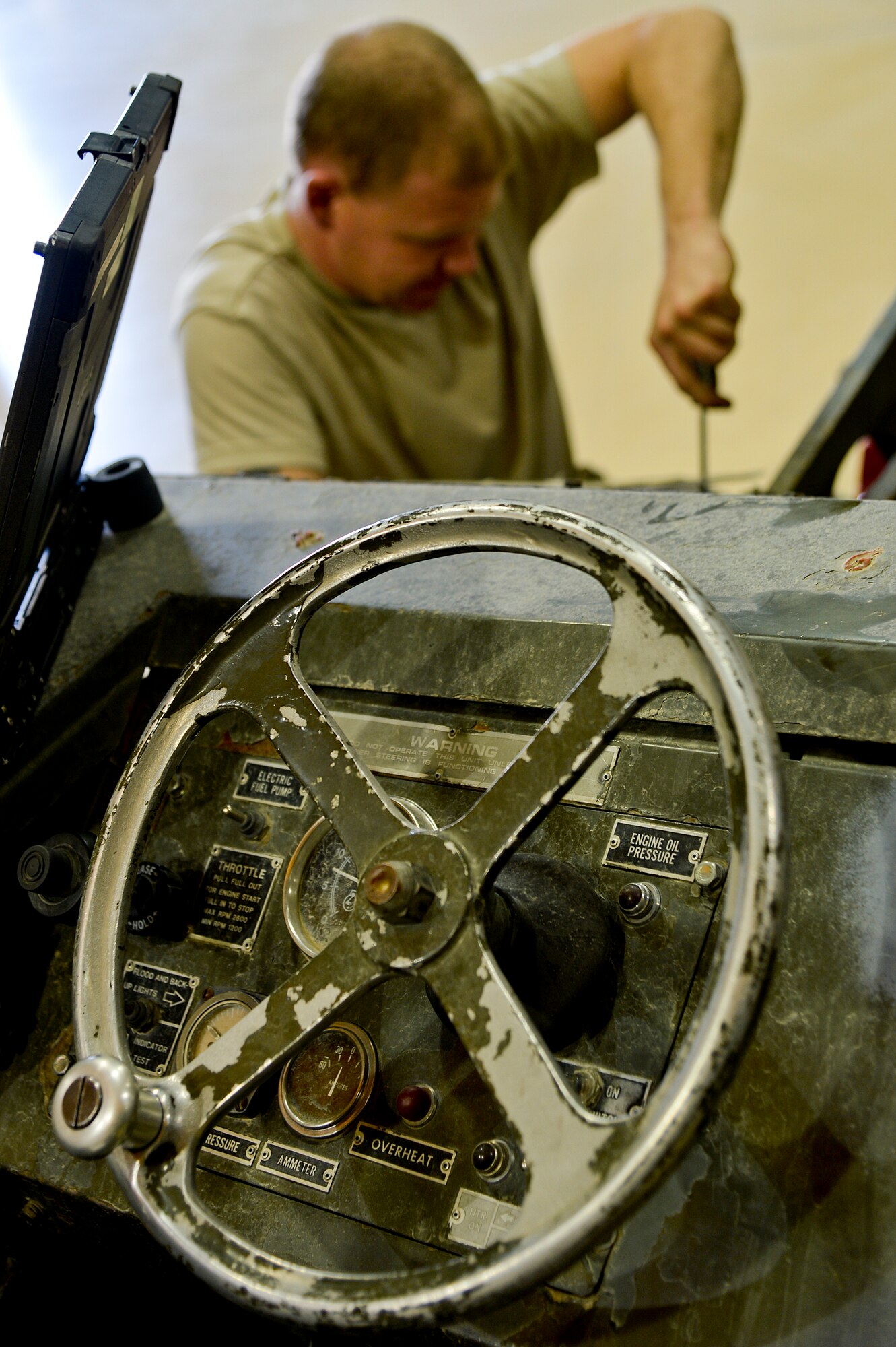 U.S. Air Force Senior Airman John Little, 455th Expeditionary Maintenance Squadron AGE technician, works on a bomb lift at Bagram Airfield, Afghanistan, Feb. 28, 2014. AGE maintains, services and performs operation checks on the ground equipment used on the aircraft at Bagram. (U.S. Air Force photo by Senior Airman Kayla Newman/Released)