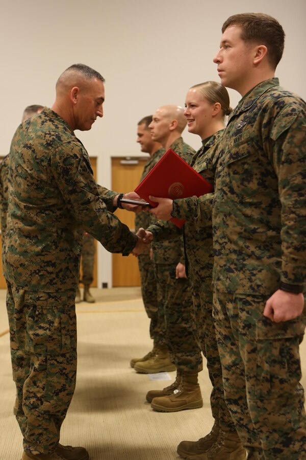Brigadier Gen. James W. Lukeman, the 2nd Marine Division commanding general, congratulates Navy Petty Officer 3rd Class Brooke E. Lopshire, the religious program specialist with Headquarters Battalion, 2nd Marine Division, on her achievement as the Junior Sailor of The Quarter during the Morning Awards Ceremony aboard Marine Corps Base Camp Lejeune Feb. 27, 2014. The Junior Sailor of The Quarter Award is presented to sailors (E-4 through E-5) who perform their duties in a highly exemplary and professional matter.