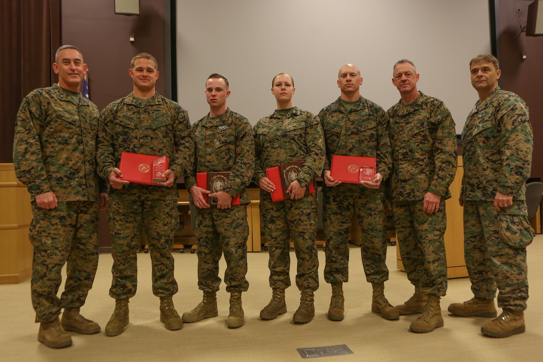 From left to right: Brigadier Gen. James W. Lukeman, Sgt. Joshua L. Moore, Petty Officer 3rd Class Kyle R. Townsend, Petty Officer 3rd Class Brooke E. Lopshire, Cpl. Andrew L. Sirois, Sgt. Maj. Bryan K. Zickefoose and Navy Master Chief Petty Officer Russell W. Folley, pose for a picture during the Morning Awards Ceremony Feb. 27, 2014 aboard Marine Corps Base Camp Lejeune. Two Marines and three sailors were recognized for outstanding performance.