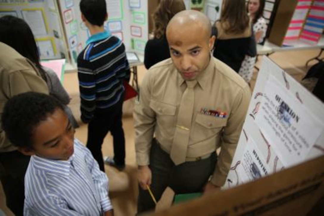 Sergeant Julio Acevedo, noncommissioned officer in charge of the administrative section on Marine Corps Logistics Base Barstow, Calif., goes over the science fair project of a student with Barstow Unified School District, Feb. 19. Several Marines here, along with members of the Chamber of Commerce, members from the Barstow Police Department and several local organizations, helped judge the 2014 Barstow Unified School District Science Fair.


