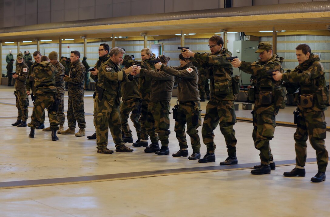 Service members with 2nd Supply Battalion, Combat Logistics Regiment 25, 2nd Marine Logistics Group and medical officers with Evacuation Company Task Unit, Host Nation Support Battalion practice sighting in with Glock P-80s in an indoor firing range at Vaernes Garrison, Norway, Feb. 27, 2014. U.S. Navy corpsmen and Norwegian army medical officers trained together to gain a greater appreciation for each nation’s medical techniques and to increase interoperability between the countries.