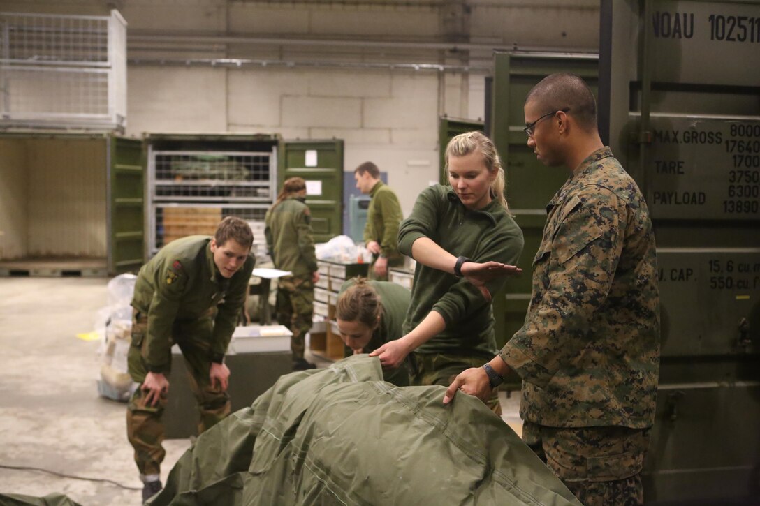 Seaman Marq C. Heusner, a Mililani, Hawaii, native and hospital corpsman with 2nd Supply Battalion, Combat Logistics Regiment 25, 2nd Marine Logistics Group helps medical officers with Joint Medical Task Force, Host Nation Support Battalion set up an inflatable stationary aid station at Vaernes Garrison, Norway, Feb. 28, 2014. Corpsmen with 2nd Supply Bn. assisted in the setup of the SAS to learn about Norwegian equipment and integrate with ECTU prior to Cold Response 2014.