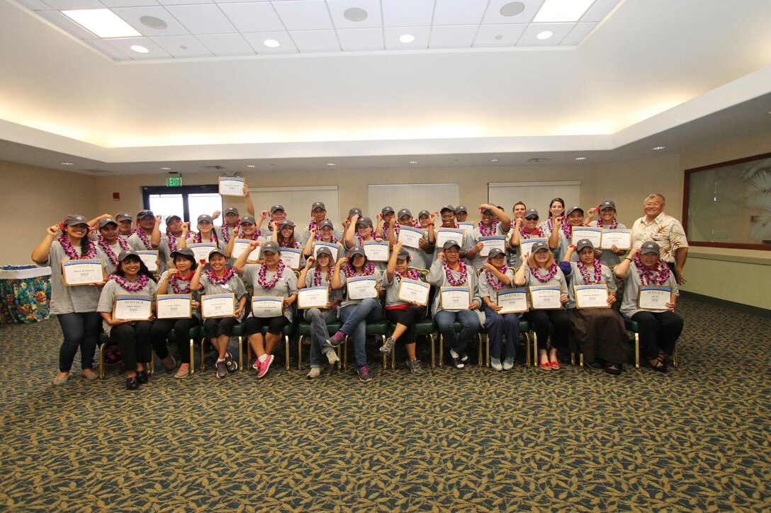 The staff of The Lodge at Kaneohe Bay pose with John Nishida, the director of Food and Hospitality (right) for a photo opportunity with their certificates of completion at Fairways Ballroom at the Kaneohe Klipper Golf Course, Feb. 14, 2014 after finishing training for the new Inns of the Corps standardization. (Photo courtesy of Sharon Cacurak, Marine Corps Community Services Marketing)