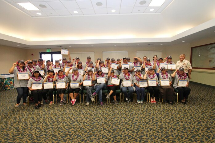 The staff of The Lodge at Kaneohe Bay pose with John Nishida, the director of Food and Hospitality (right) for a photo opportunity with their certificates of completion at Fairways Ballroom at the Kaneohe Klipper Golf Course, Feb. 14, 2014 after finishing training for the new Inns of the Corps standardization. (Photo courtesy of Sharon Cacurak, Marine Corps Community Services Marketing)