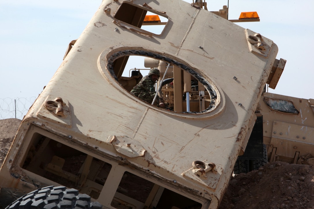 An Afghan soldier with the 3rd Mobile Strike Force operates an Interim Stryker Recovery System to pull a Mine-Resistant Ambush-Protected vehicle with simulated battle damage out of a ditch during vehicle recovery training aboard Camp Leatherneck, Helmand province, Afghanistan, Feb. 23, 2014. Marines with MSF Security Force Assistance Advisor Team have been working with the 3rd MSF since August, teaching the soldiers basic vehicle maintenance and proper vehicle recovery in order to sustain continuous combat operations.