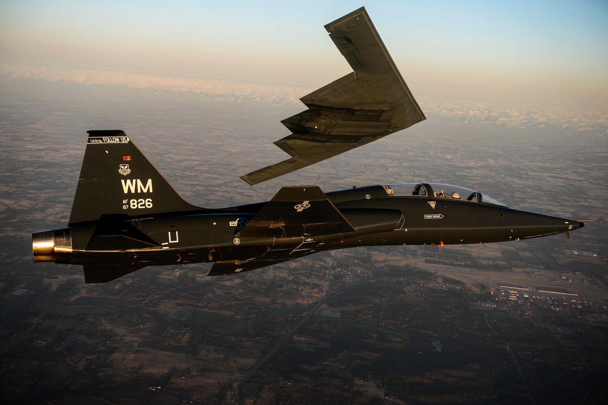 A T-38 Talon flies in formation with the B-2 Spirit of South Carolina during a training mission over Whiteman Air Force Base, Mo., Feb. 20, 2014. The B-2 Spirit is a multirole bomber capable of delivering both conventional and nuclear munitions. (U.S. Air Force photo/Staff Sgt. Jonathan Snyder)