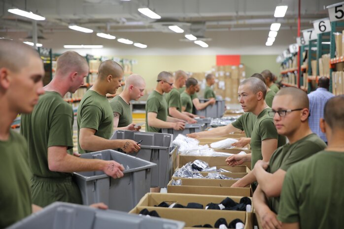 Recruits of Company I, 3rd Recruit Training Battalion, walk through a line to receive all of their uniform items during their first uniform fitting aboard the depot, Feb. 11. Recruits will return two more times to make sure the tailoring is correct and are ready to be worn at the end of recruit training.