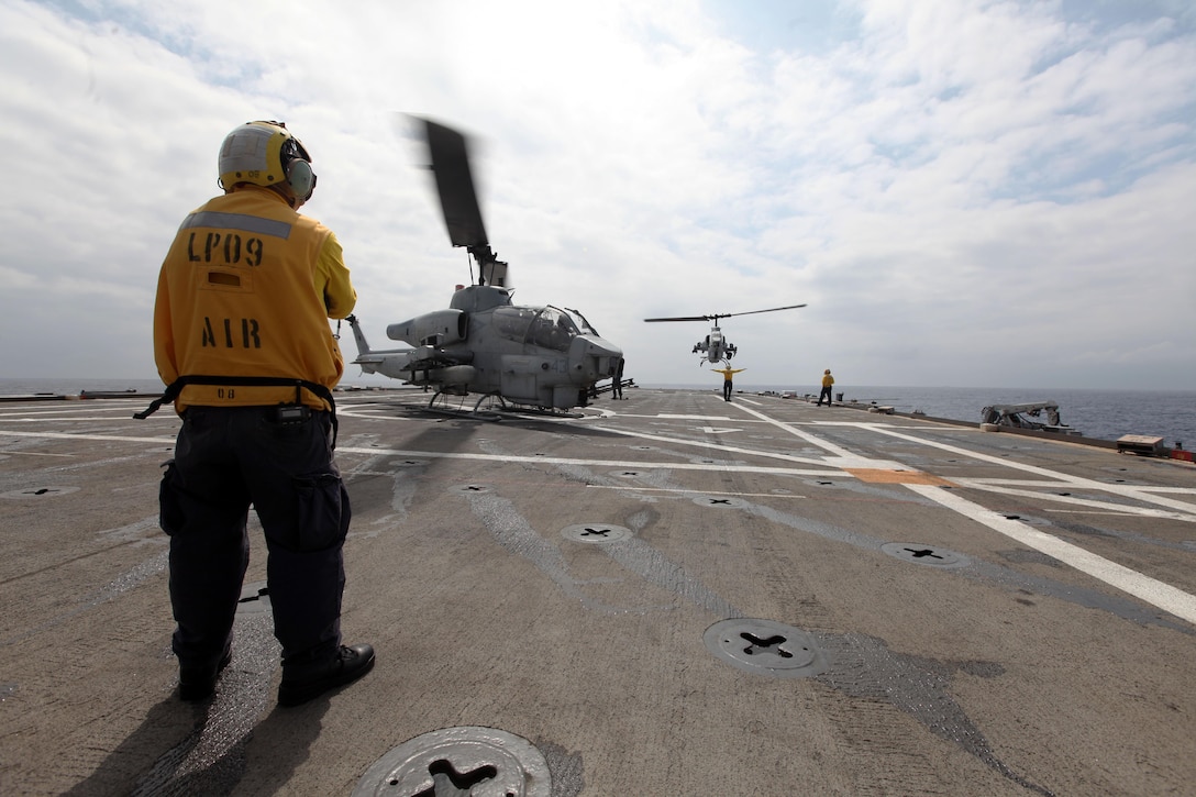 USS DENVER, At Sea – Petty Officer 3rd Class Luis Campos, an aviation boatswain’s mate (handling), looks on as other flight deck crewmen guide an AH-1W Super Cobra helicopter with Marine Medium Tiltrotor Squadron 265 (Reinforced), 31st Marine Expeditionary Unit, to the deck here, Feb. 27. Several helicopters were flown aboard as the Marines and ship’s crew begin their regularly scheduled Spring Patrol of the Asia-Pacific region. The 31st MEU is the Marine Corps’ force in readiness for the Asia-Pacific region and the only continuously forward-deployed MEU. (Marine Corps photo by Sgt. Paul Robbins Jr.) 
