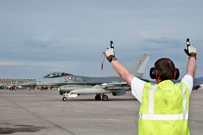 Royal Danish Air Force Lance Cpl. Robert Nielsen, 730th Fighter Squadron crew chief from Skrydstrup Air Base, Denmark, marshals in an F-16 Fighting Falcon on the Nellis Air Force Base, Nev. flightline Feb. 26, 2014.  The RDAF is participating in Red Flag 14-2; they are responsible for maintaining homeland defense and carrying out security roles for international operations. (U.S. Air Force photo by Senior Airman Matthew Lancaster)