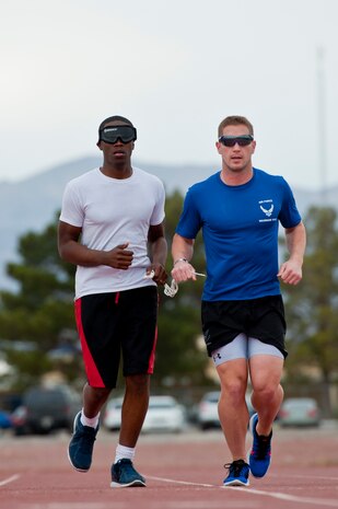 (left) Jabrier Lee and (right) Mitch Kieffer, Air Force Wounded Warrior Adaptive Sports Camp participants jog around the quarter mile track behind the Warrior Fitness Center, Feb. 26, 2014 at Nellis Air Force Base, Nev. The camp introduced wounded warriors to adaptive sports during their early stages of recovery. (U.S. Air Force photo by Senior Airman Christopher Tam)
