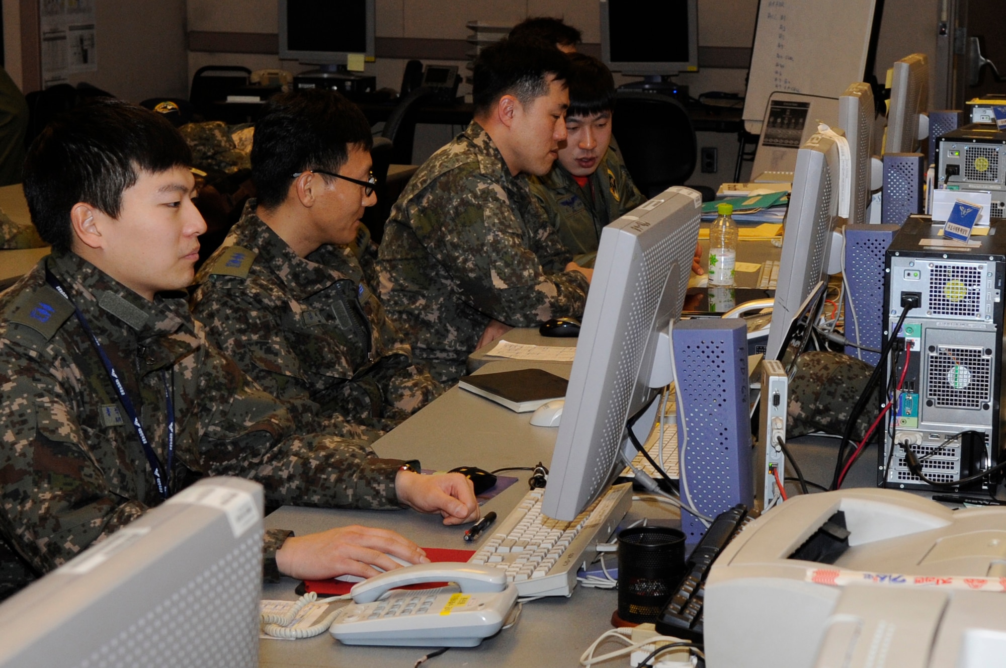 Republic of Korea Air Force members organize the movements and operations of virtual aircraft  in the Korea Air Simulation Center during Exercise Key Resolve 2014 at Osan Air Base, Republic of Korea, Feb. 28, 2014. The KASC uses modeling and simulation technology to create graphically represented, synthetic environments for training and mission planning that challenge decision makers while testing strategy, plans and doctrine. (U.S. Air Force photo/ Senior Airman Marcus Morris)