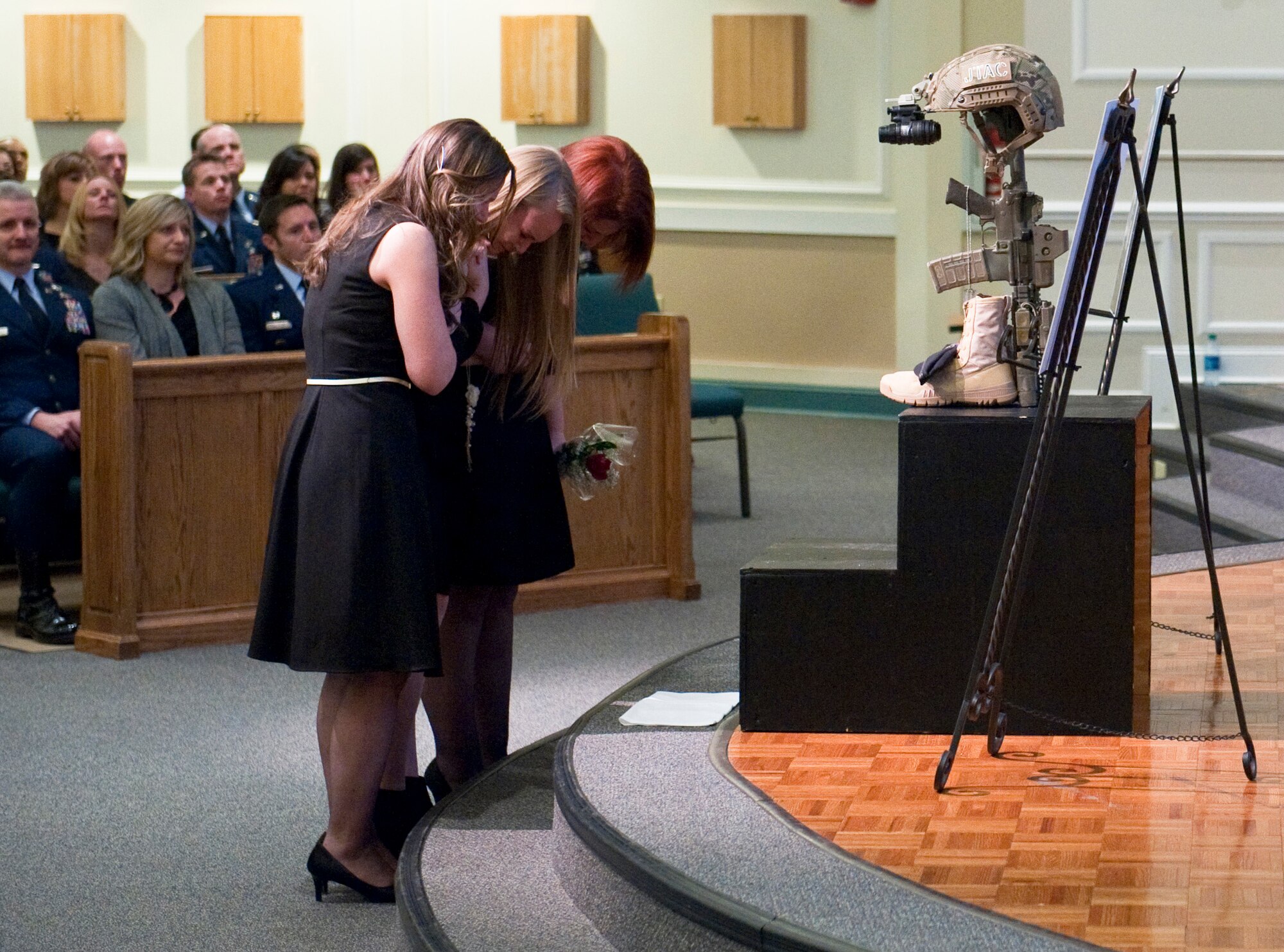 (From left to right) The widow and eldest child of Master Sgt. Josh Gavulic grieve his loss alongside another family member during a memorial service at Fort Benning's Main Post Chapel on February 28, 2014. He left behind six children. He was buried at the Fort Mitchell National Veteran's Cemetery just outside the gates of Fort Benning following a funeral service March 3, 2014 at Cascade Hills Baptist Church in Columbus, Ga., (U.S. Army Photo by Patrick Albright/MCoE Photographer)
