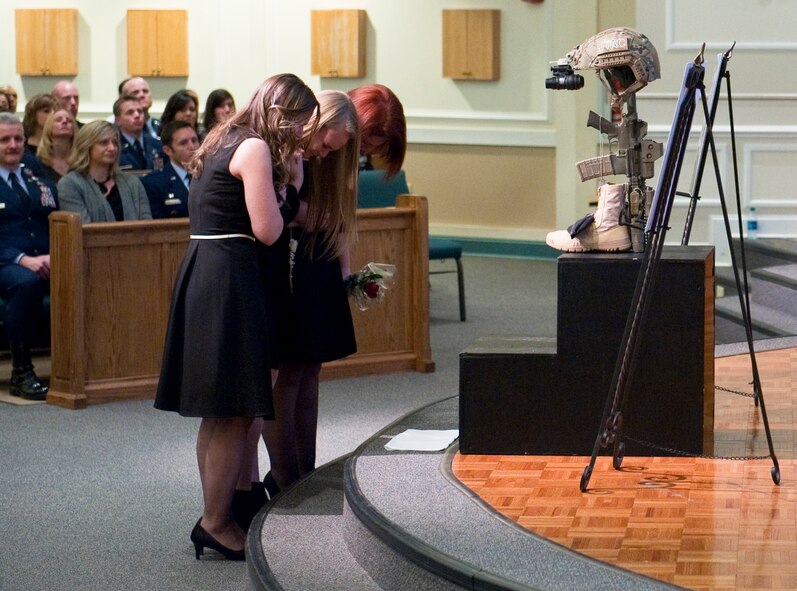 (From left to right) The widow and eldest child of Master Sgt. Josh Gavulic grieve his loss alongside another family member during a memorial service at Fort Benning's Main Post Chapel on February 28, 2014. He left behind six children. He was buried at the Fort Mitchell National Veteran's Cemetery just outside the gates of Fort Benning following a funeral service March 3, 2014 at Cascade Hills Baptist Church in Columbus, Ga., (U.S. Army Photo by Patrick Albright/MCoE Photographer)

