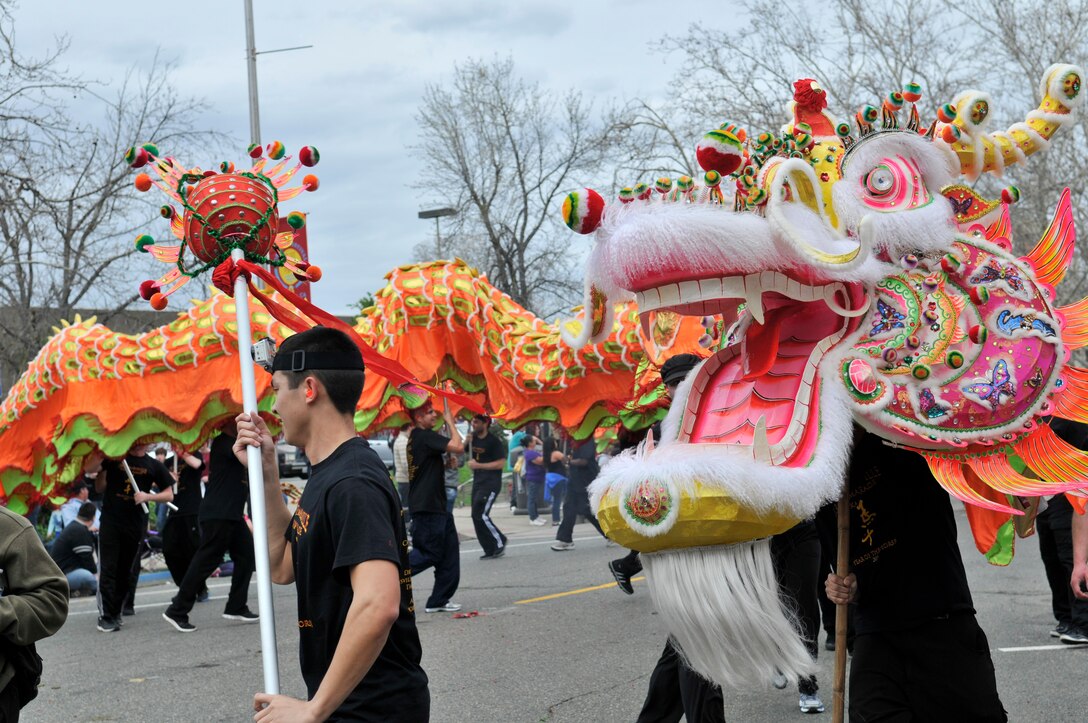 Senior Airman Adam Keydeniers, 9th Aircraft Maintenance Squadron, guides the Bok Kai dragon during the 134th Annual Bok Kai Parade in Marysville, Calif., March 1, 2014. Beale Air Force Base members and volunteers from the local community worked as a team to carry the 175-foot-long dragon throughout the parade. (U.S. Air Force photo by Airman 1st Class Shana Wojcik/Released)