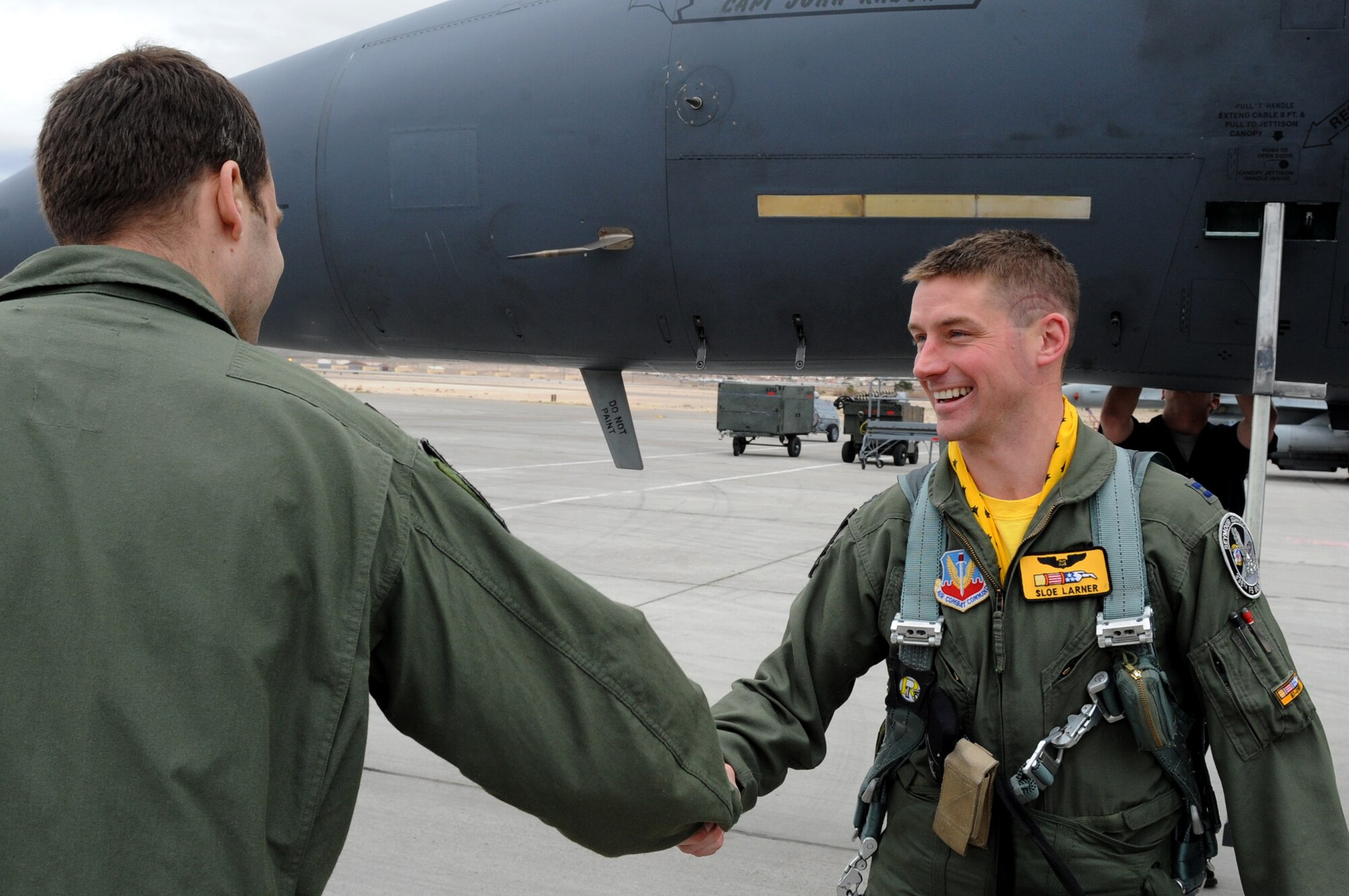 Capt. Thomas Larner, 336th Fighter Squadron weapons systems operator, is greeted by Maj. Anthony  Breck, 336th FS weapons systems operator, upon arriving to Nellis Air Force Base, Nev., Feb. 28, 2014. Larner and more than 250 other Airmen from the 4th Fighter Wing flew to Nellis AFB for Red Flag 14-2. (U.S. Air Force photo/Staff Sgt. Chuck Broadway)