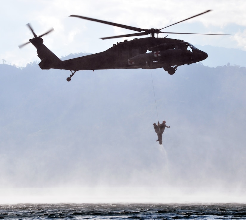 A flight medic from Joint Task Force-Bravo's 1-228th Aviation Regiment "rescues" a member of Joint Task Force-Bravo from the waters of Lake Yojoa, Honduras, during an overwater hoist training exercise, Feb. 25, 2014. During the exercise, flight medics practiced rescuing members from the water using a hoist lowered from a UH-60 Black Hawk helicopter. (U.S. Air Force photo by Capt. Zach Anderson)

