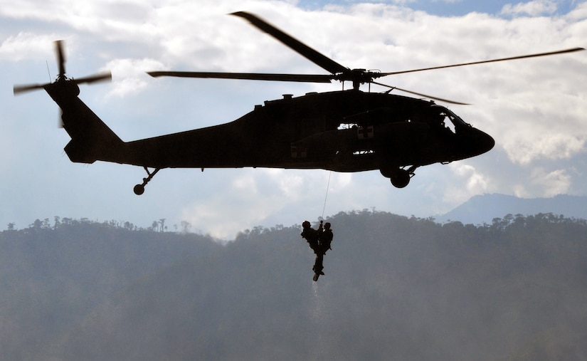 A flight medic from Joint Task Force-Bravo's 1-228th Aviation Regiment "rescues" a member of Joint Task Force-Bravo from the waters of Lake Yojoa, Honduras, during an overwater hoist training exercise, Feb. 25, 2014. During the exercise, flight medics practiced rescuing members from the water using a hoist lowered from a UH-60 Black Hawk helicopter. (U.S. Air Force photo by Capt. Zach Anderson)

