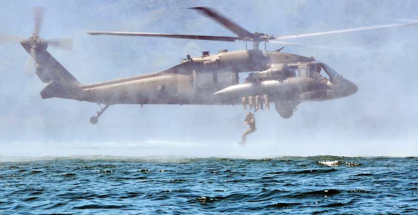 A member of Joint Task Force-Bravo jumps from a UH-60 Blackhawk helicopter during helocast training at Lake Yojoa, Honduras, Feb. 25, 2014. Several members of the Task Force spent the day training on helocasting, caving ladder, and overwater hoist operations. (U.S. Air Force photo by Capt. Zach Anderson)