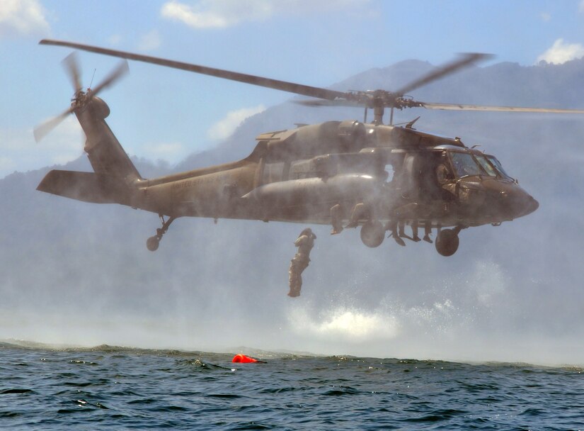 A member of Joint Task Force-Bravo jumps from a UH-60 Blackhawk helicopter during helocast training at Lake Yojoa, Honduras, Feb. 25, 2014. Several members of the Task Force spent the day training on helocasting, caving ladder, and overwater hoist operations. (U.S. Air Force photo by Capt. Zach Anderson)
