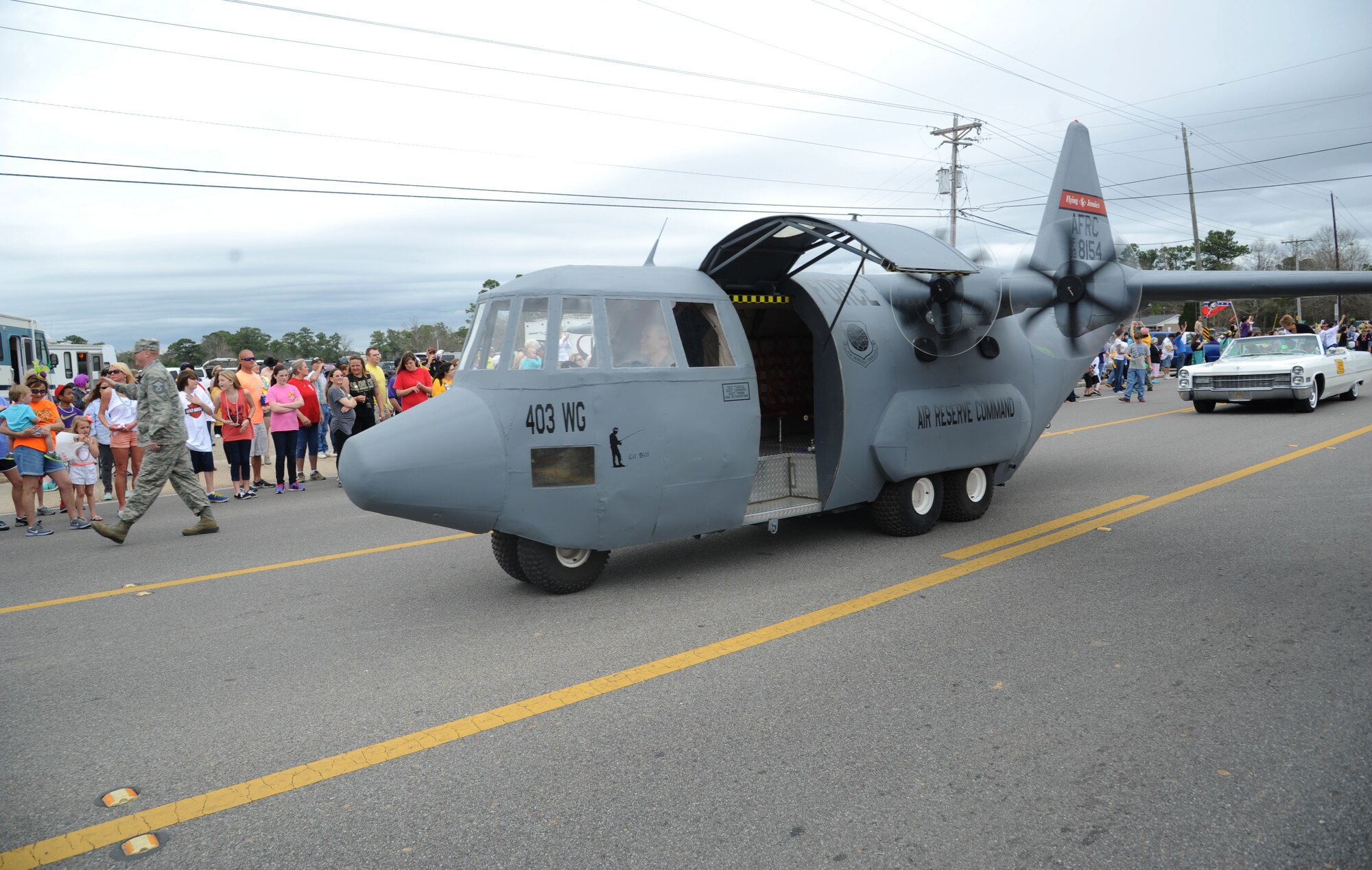 The 403rd Wing’s C-130J aircraft prototype from Keesler rolls through the crowded streets during the 26th Annual North Bay Area Mardi Gras Parade in D’Iberville, Miss., March 2, 2014.  Leadership from the 81st Training Wing, the Keesler Honor Guard, Airmen carrying the 50 state flags and the 81st Training Group drum and bugle corps also participated in the festivities.  (U.S. Air Force photo by Kemberly Groue)