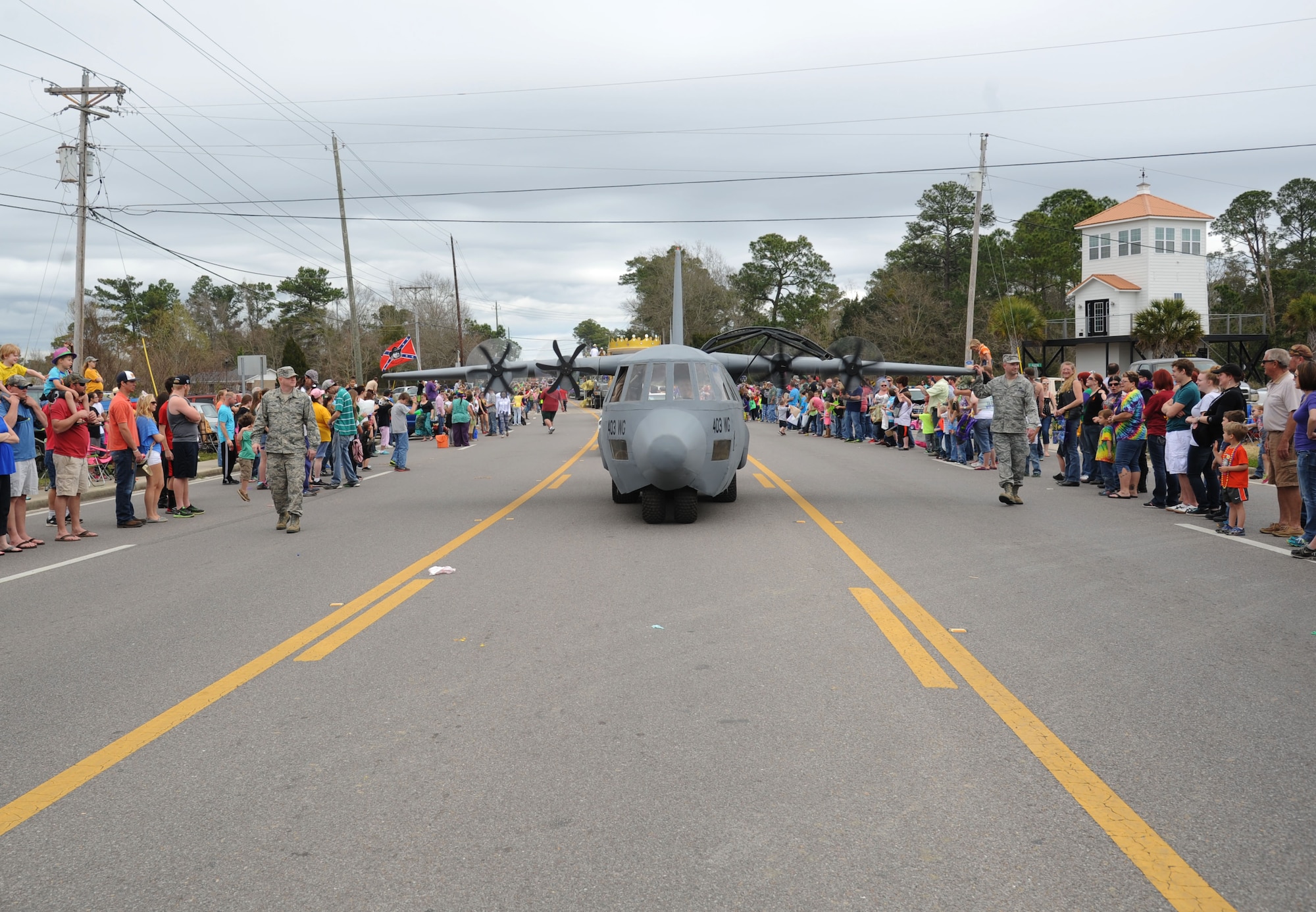 The 403rd Wing’s C-130J aircraft prototype from Keesler rolls through the crowded streets during the 26th Annual North Bay Area Mardi Gras Parade in D’Iberville, Miss., March 2, 2014.  Leadership from the 81st Training Wing, the Keesler Honor Guard, Airmen carrying the 50 state flags and the 81st Training Group drum and bugle corps also participated in the festivities.  (U.S. Air Force photo by Kemberly Groue)