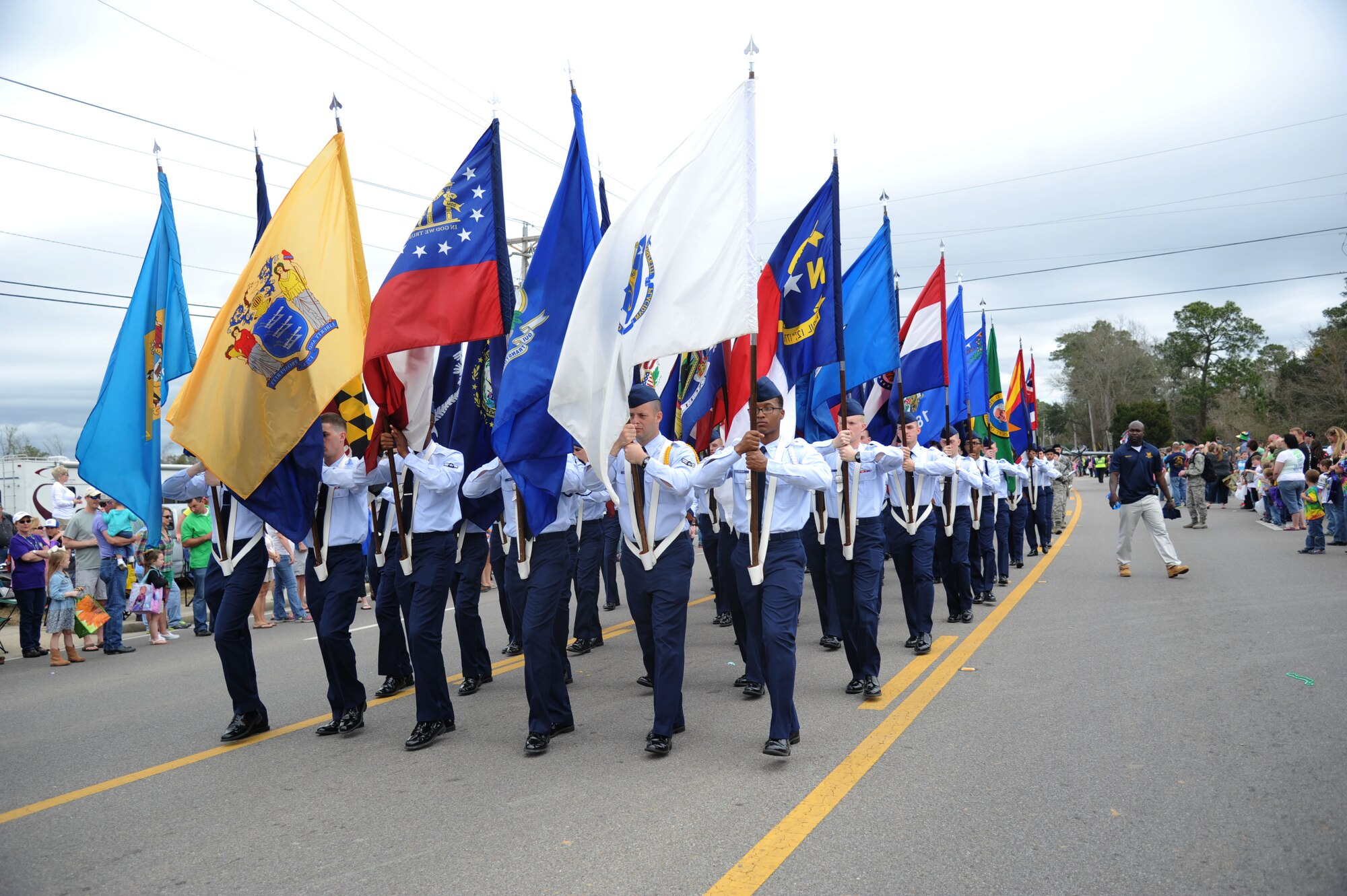 Airmen carrying the 50 state flags follow behind the Keesler Honor Guard leading the 26th Annual North Bay Area Mardi Gras Parade in D’Iberville, Miss., March 2, 2014.  Leadership from the 81st Training Wing and the 81st Training Group drum and bugle corps also participated in the festivities.  (U.S. Air Force photo by Kemberly Groue)