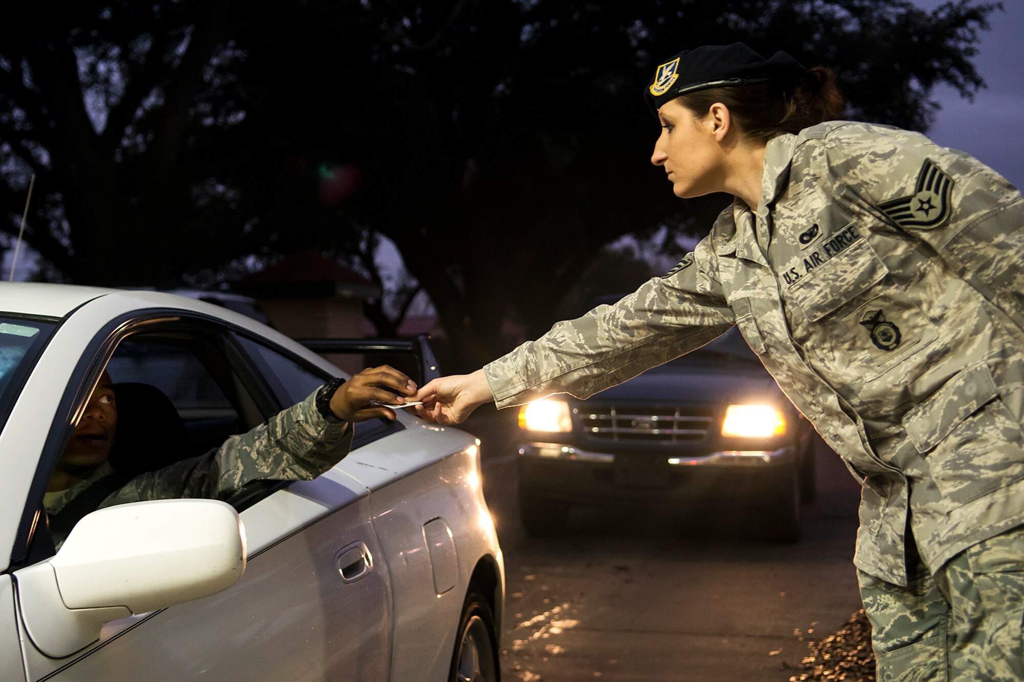 U.S. Air Force Staff Sgt. Rebekah Ott, 307th Security Forces Squadron (SFS), hands an identification card back to a member of the 307th Bomb Squadron during gate duty on Mar. 2, 2014, Barksdale Air Force Base, La. During the wing's Unit Training Assemblies, several hundred Airmen enter through the Barksdale gates causing traffic congestion which the SFS try to alleviate by assigning Airmen to assist 2nd Bomb Wing security forces with identification checks. (U.S. Air Force photo by Master Sgt. Greg Steele/Released)