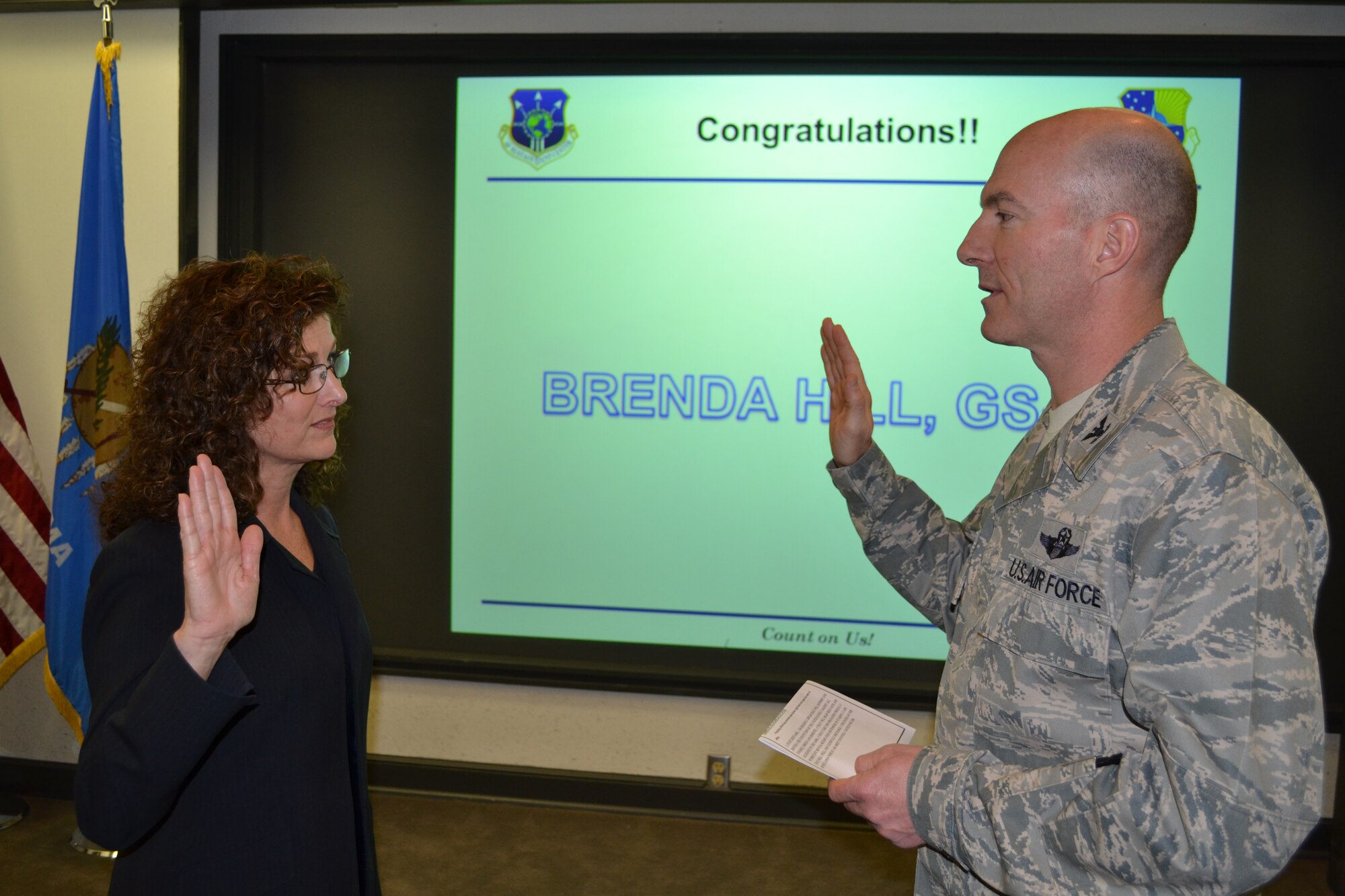 During a ceremony Feb. 25, 72nd Air Base Wing Commander Col. Christopher Azzano administers the oath of office to Brenda Hill, as the new director of the 72nd Air Base Wing Communications Directorate. Ms. Hill also pinned on GS-15. (Air Force photo by Ron Mullan)