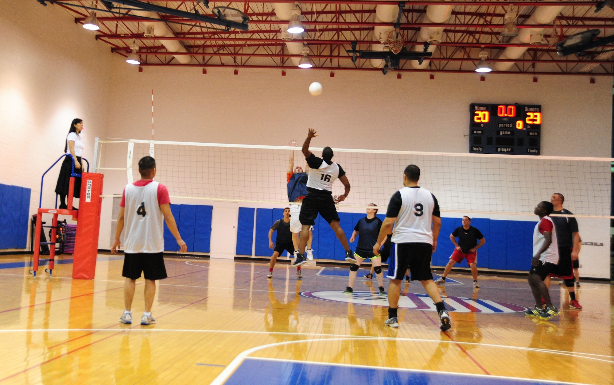 Members from the 509th Force Support Squadron intramural volleyball team, defend during the second half of a volleyball game against the 709th Munitions Support Squadron. The 509th FSS defeated the 709th MUNS after two games one with an overall score of 50-34. (U.S. Air Force photo by Staff Sgt. Nick Wilson/Released)