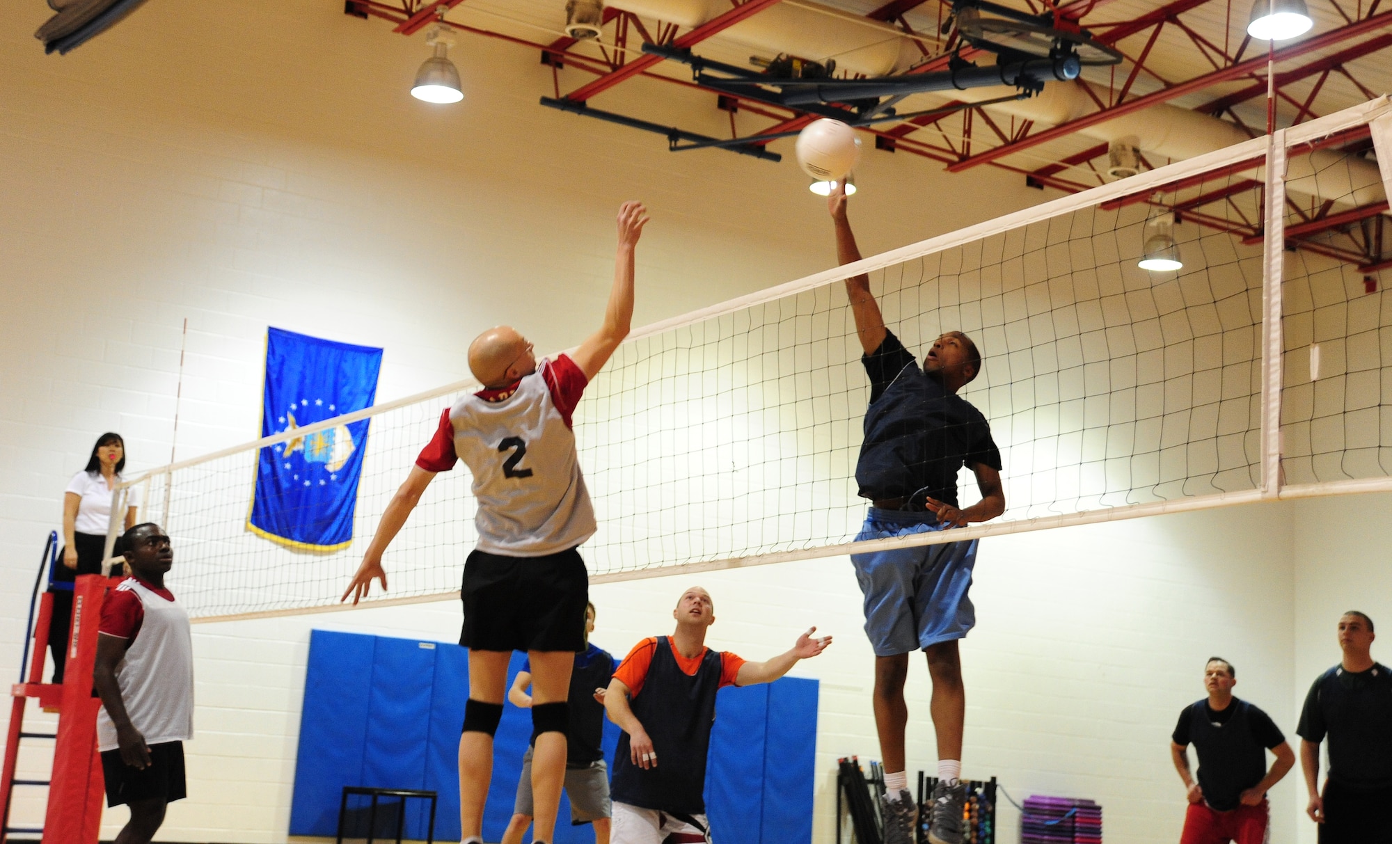 Kevin Hostettler, 509th Force Support Squadron intramural volleyball team, jumps to defend the ball from Desmond Reaves, 709th Munitions Support Squadron, during the second half of a volleyball game at the Fitness Center of Whiteman Air Force Base, Mo., Feb. 18, 2014. The 509th FSS defeated the 709th MUNS during game two with a score of 25-20. (U.S. Air Force photo by Staff Sgt. Nick Wilson/Released)