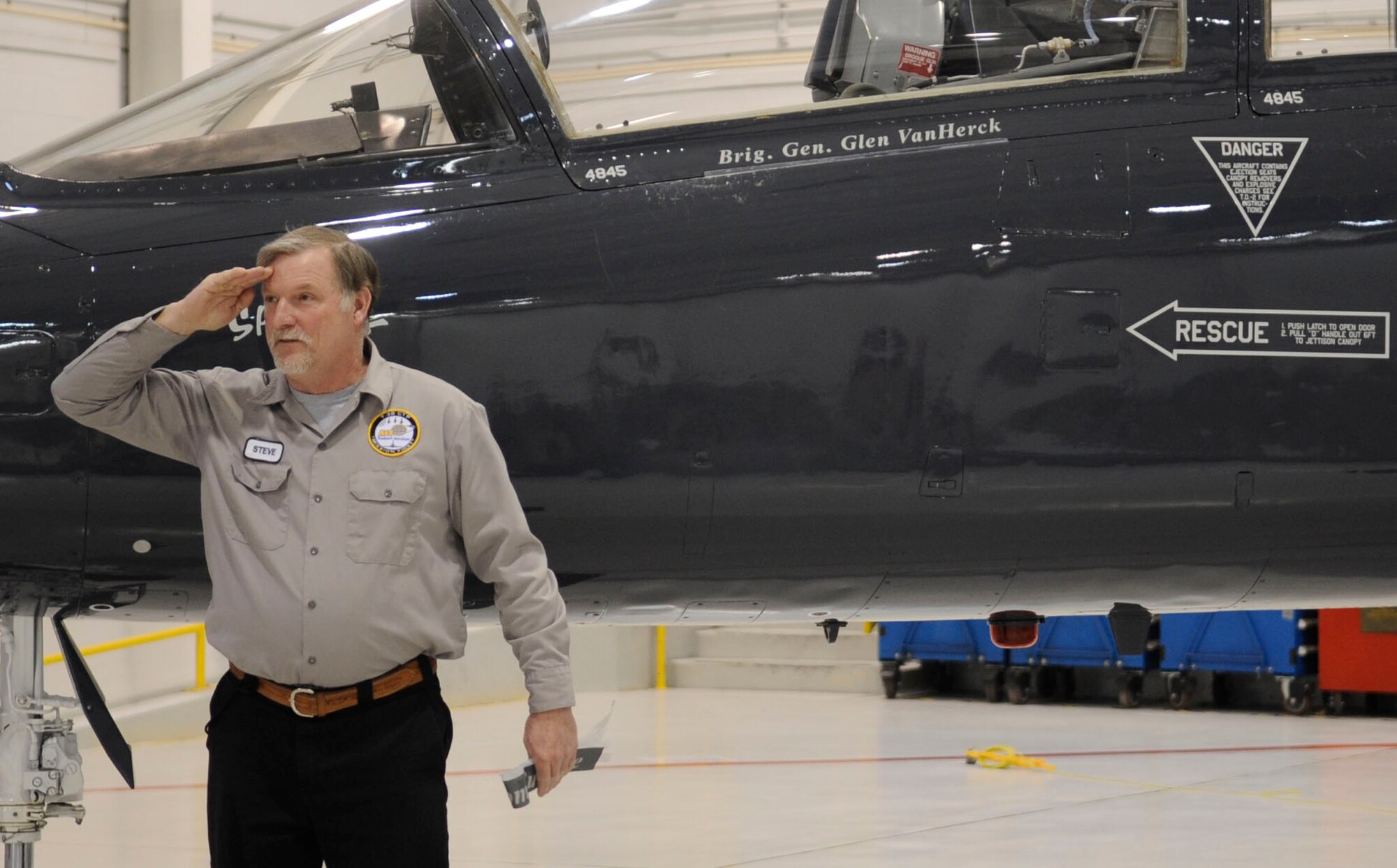 Mr. Steven Baum, 509th Maintenance Group, T-38 Talon crew chief, salutes the newest 509th Bomb Wing commander, Brig. Gen. Glen VanHerck, after unveiling his name on a T-38 aircraft during the change of command ceremony. As part of an Air Force tradition one of the aircraft is painted with the new commander’s name. (U.S. Air Force photo by Staff Sgt. Alexandra M. Boutte/Released)