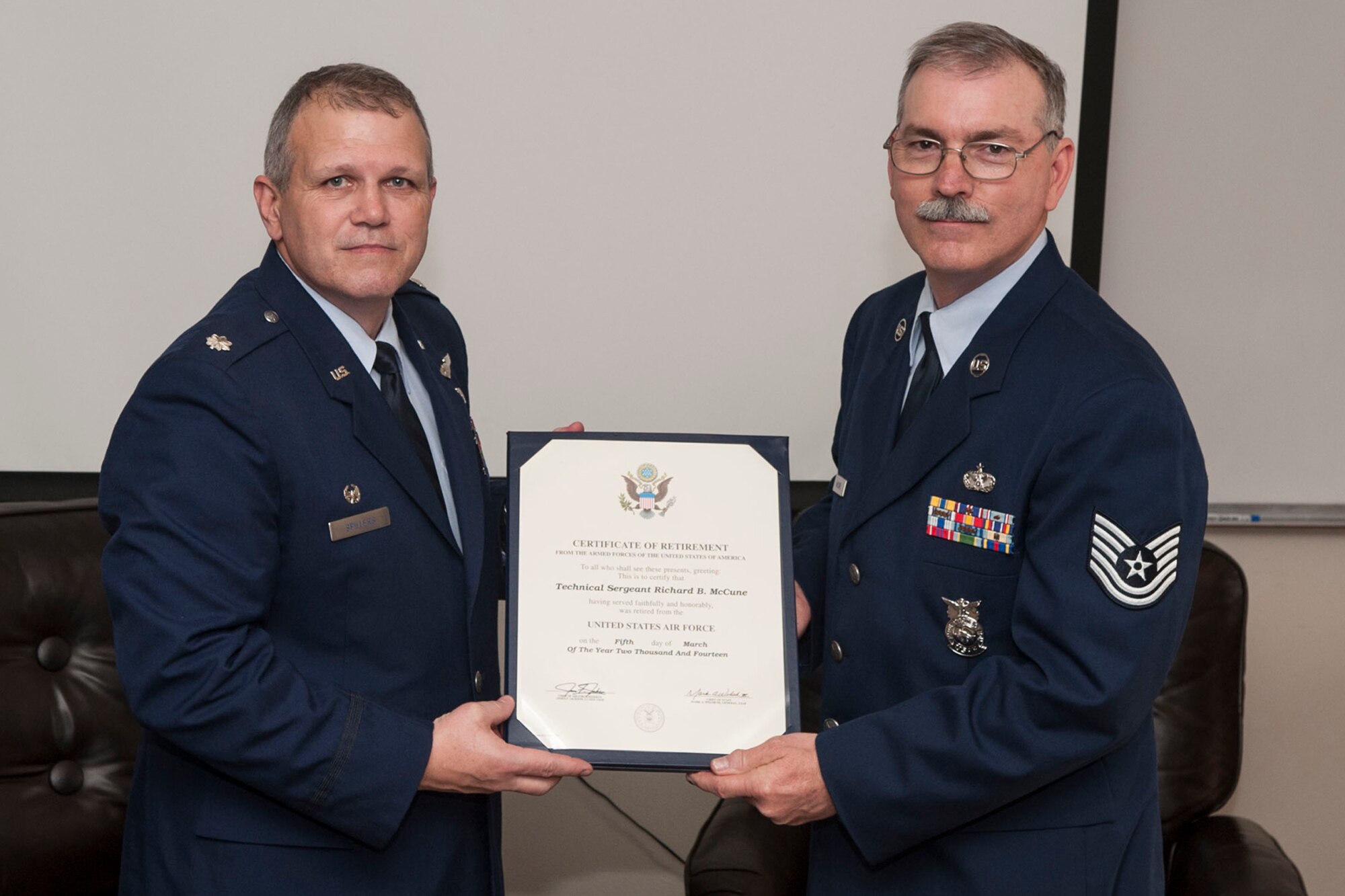 U.S. Air Force Lt. Col. Allen Spillers, 307th Civil Engineer Squadron commander, presents a Retirement Certificate to Tech. Sgt. Richard McCune during a ceremony on Mar. 1, 2014, Barksdale Air Force Base, La. McCune, a Fireman assigned to the 307th Fire Protection Flight is retiring after serving more than 22 years of service. (U.S. Air Force photo by Master Sgt. Jeff Walston/Released)