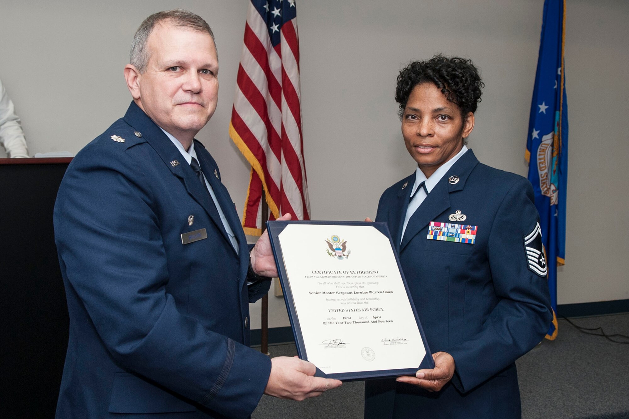 U.S. Air Force Lt. Col. Allen Spillers, 307th Civil Engineer Squadron commander, presents a Retirement Certificate to Senior Master Sgt. Laraine Warren-Dawn during a ceremony on Mar. 1, 2014, Barksdale Air Force Base, La. Warren-Dawn is the Superintendent assigned to the 307th Bomb Wing Services Flight and is retiring after serving 34 years in the military. (U.S. Air Force photo by Master Sgt. Jeff Walston/Released)