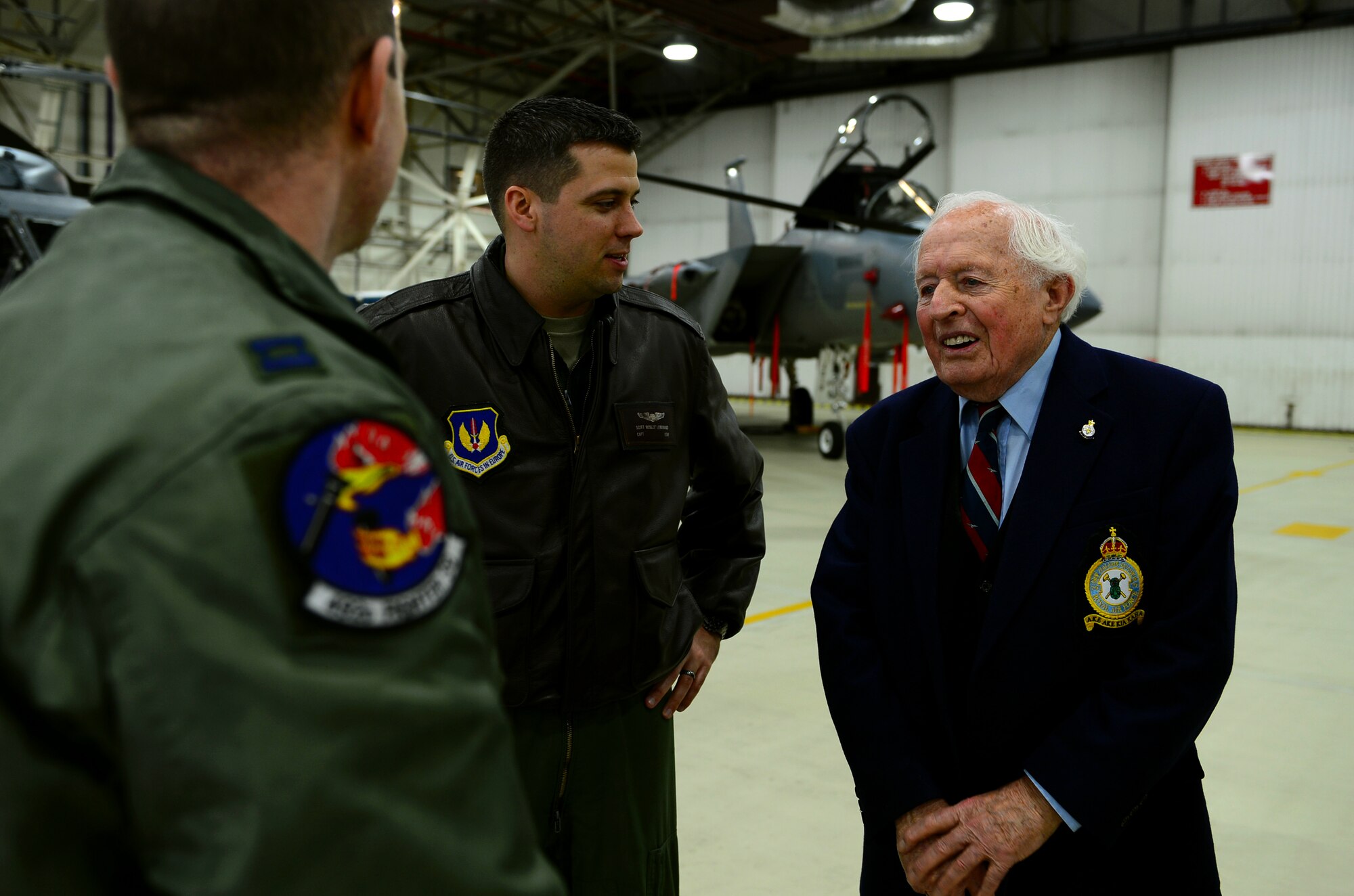 Capt. Scott Leibbrandt, 492nd Fighter Squadron pilot and Capt. Jonathan Bell, 492nd Fighter Squadron weapon systems officer compare modern flying capabilities and World War II era flying techniques with Ron Brown, former Royal Air Force Wellington Bomber crew member, at RAF Lakenheath, England, Feb. 28, 2014. The WWII pilot visited RAFs Feltwell and Lakenheath to tour the bases and learn about the mission of the 48th Fighter Wing. (U.S. Air Force photo by Airman 1st Class Dawn M. Weber/Released)