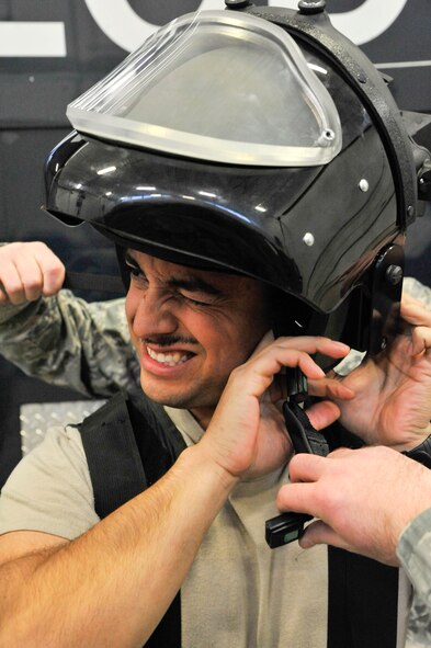 Senior Airman Fernando Aguilera, 509th Civil Engineer Squadron explosive ordnance disposal team member, tightens his bomb suit helmet at Whiteman Air Force Base, Mo., Feb. 11, 2014. The bomb suit is designed to protect the subject from detonations. (U.S. Air Force photo by Airman 1st Class Keenan Berry/Released)