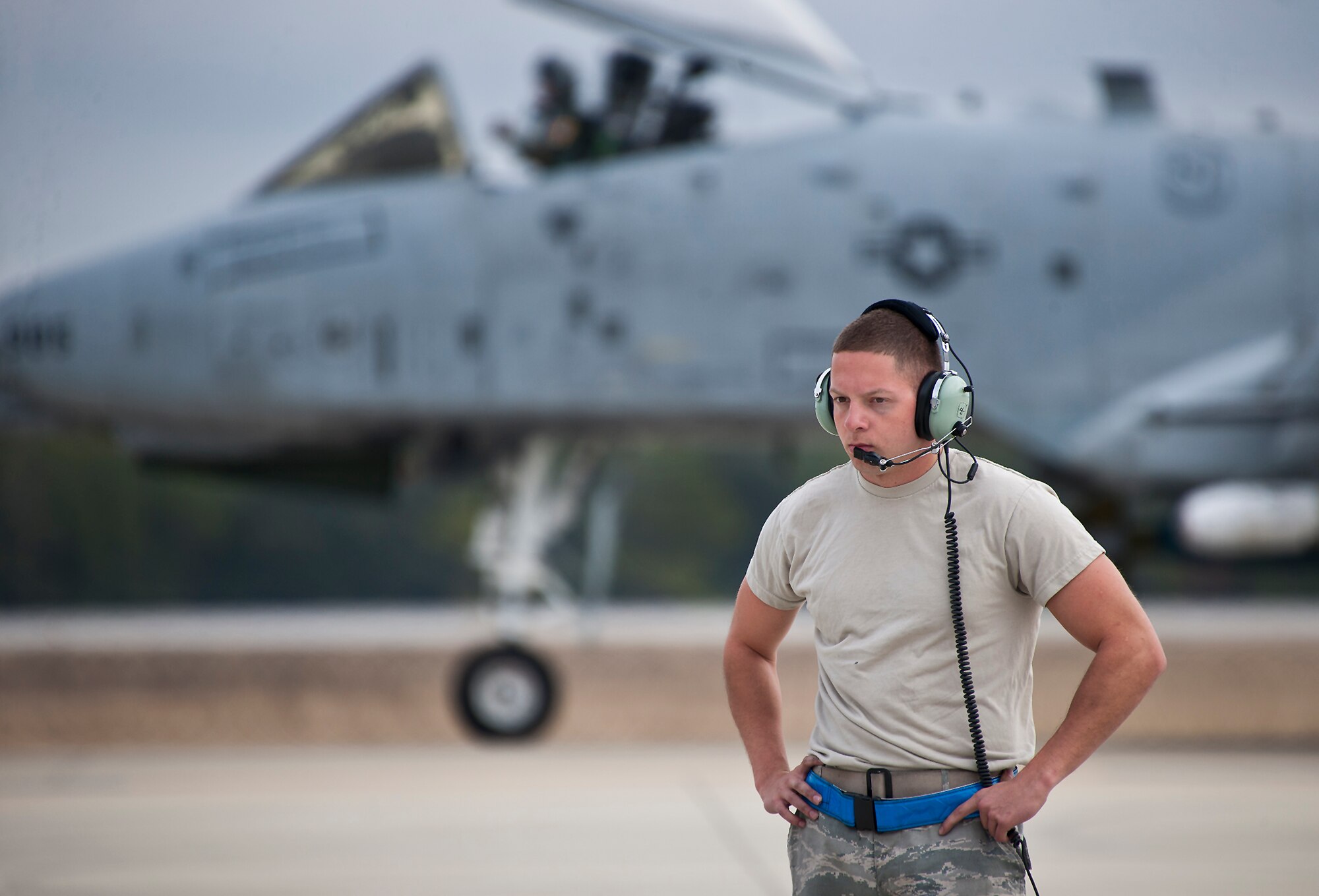 An A-10 Thunderbolt II passes behind Airman Kevin Teto, of the 355th Aircraft Maintenance Squadron, as he prepares to launch his own aircraft for a sortie at Eglin Air Force Base, Fla., Feb. 19. The A-10s from Davis-Monthan Air Force Base, Ariz., participated in the week-long Weapon System Evaluation Program known as Combat Hammer, in which they released air-to-ground munitions.  The Combat Hammer WSEP program is managed by the 86th Fighter Weapons Squadron, part of the 53rd Wing.  (U.S. Air Force photo/Samuel King Jr.)