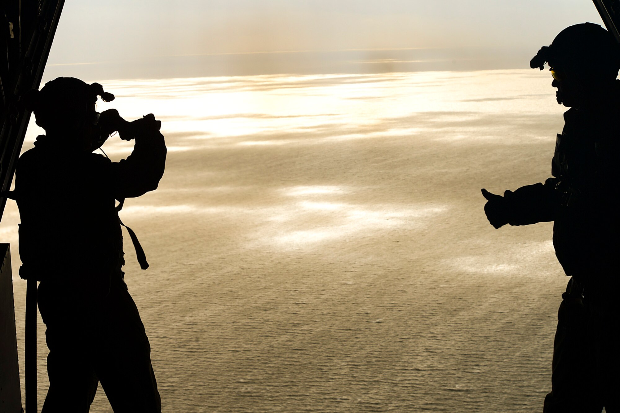 Staff Sgts. Josh Fattorusso and Staff Sgt. Brett Bollinger, 7th Special Operations Squadron MC-130H Combat Talon II loadmasters from Royal Air Force Mildenhall, England, successfully assist in the static-line drop of seven pararescuemen off the Felixstowe coast, Feb. 25, 2014. RAFs Lakenheath and Mildenhall worked together during the combat search and rescue training event. (U.S. Air Force photo by Airman 1st Class Dana J. Butler/Released)