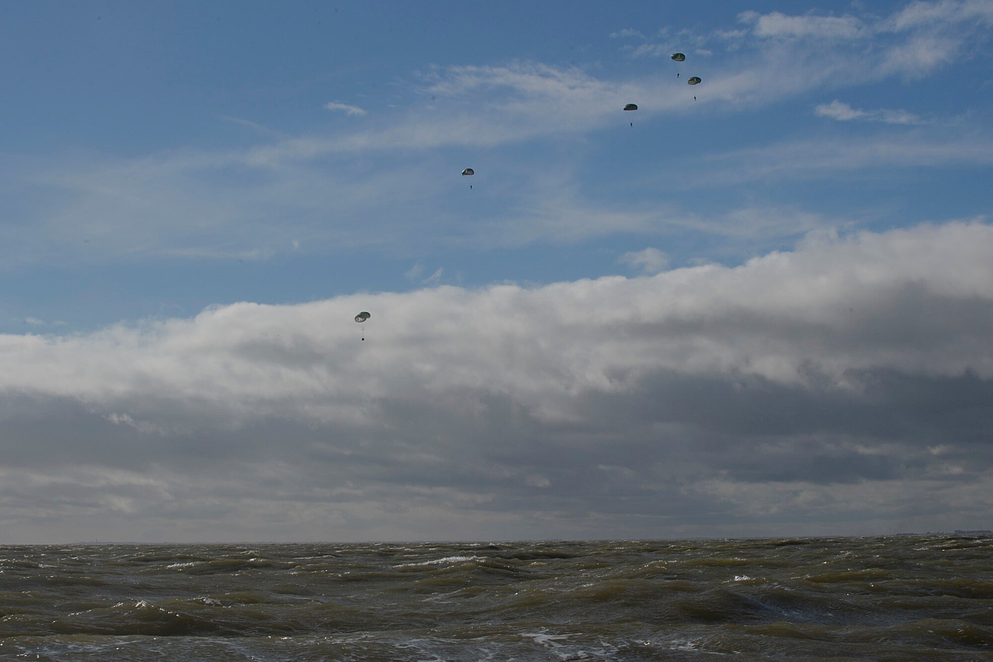 Pararescue specialists from the 56th Rescue Squadron parachute into the water during a training exercise off the coast of Felixstowe, England, Feb. 25, 2014. Pararescuemen are trained to provide emergency medical treatment in adverse terrain and conditions in combat or peacetime. (U.S Air Force photo by Airman 1st Class Nigel Sandridge/Released)