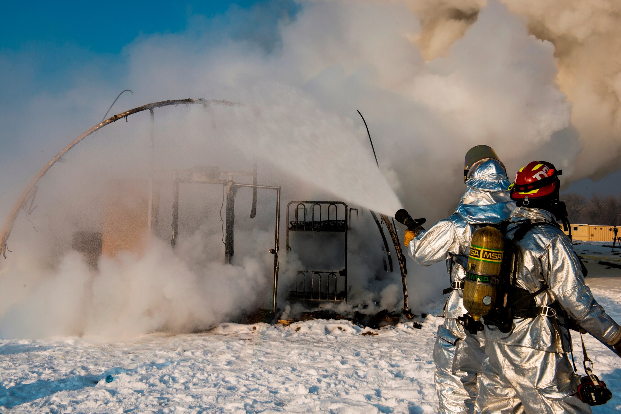 Firefighters from the 376 Expeditionary Civil Engineer Squadron douse the remaining flames of a controlled tent fire at Transit Center at Manas, Kyrgyzstan, March 1, 2014. The 376th ECES used the training to demonstrate how fast the tents burn: In this case, approximately two and a half minutes. The transient tent was the last in Hotel Alaska, marking another step in closing the facility and removing U.S. troops from the Transit Center by July 11, 2014. (U.S. Air Force photo/Staff Sgt. Travis Edwards) 