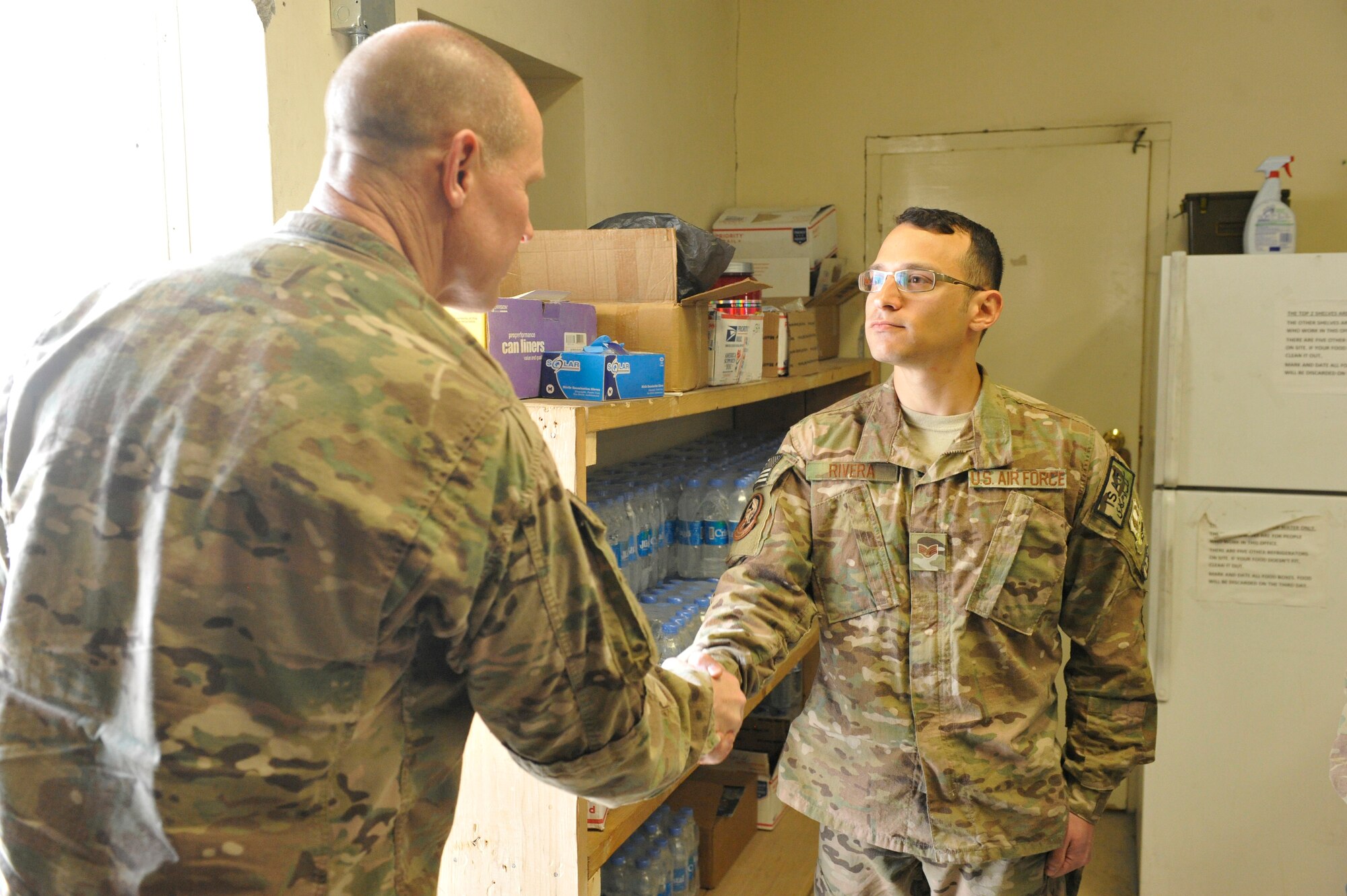 U.S. Air Force Staff Sgt. Daniel Rivera is coined for his outstanding performance by Brig. Gen. Patrick Malackowski, 455th Air Expeditionary Wing commander, at Jalalabad Airfield, Afghanistan, Feb. 25, 2014. Malackowski spent the day talking to airmen at Jalalabad and recognizing outstanding performers there.(U.S. Air Force photo by Senior Master Sgt. Gary J. Rihn/Released)