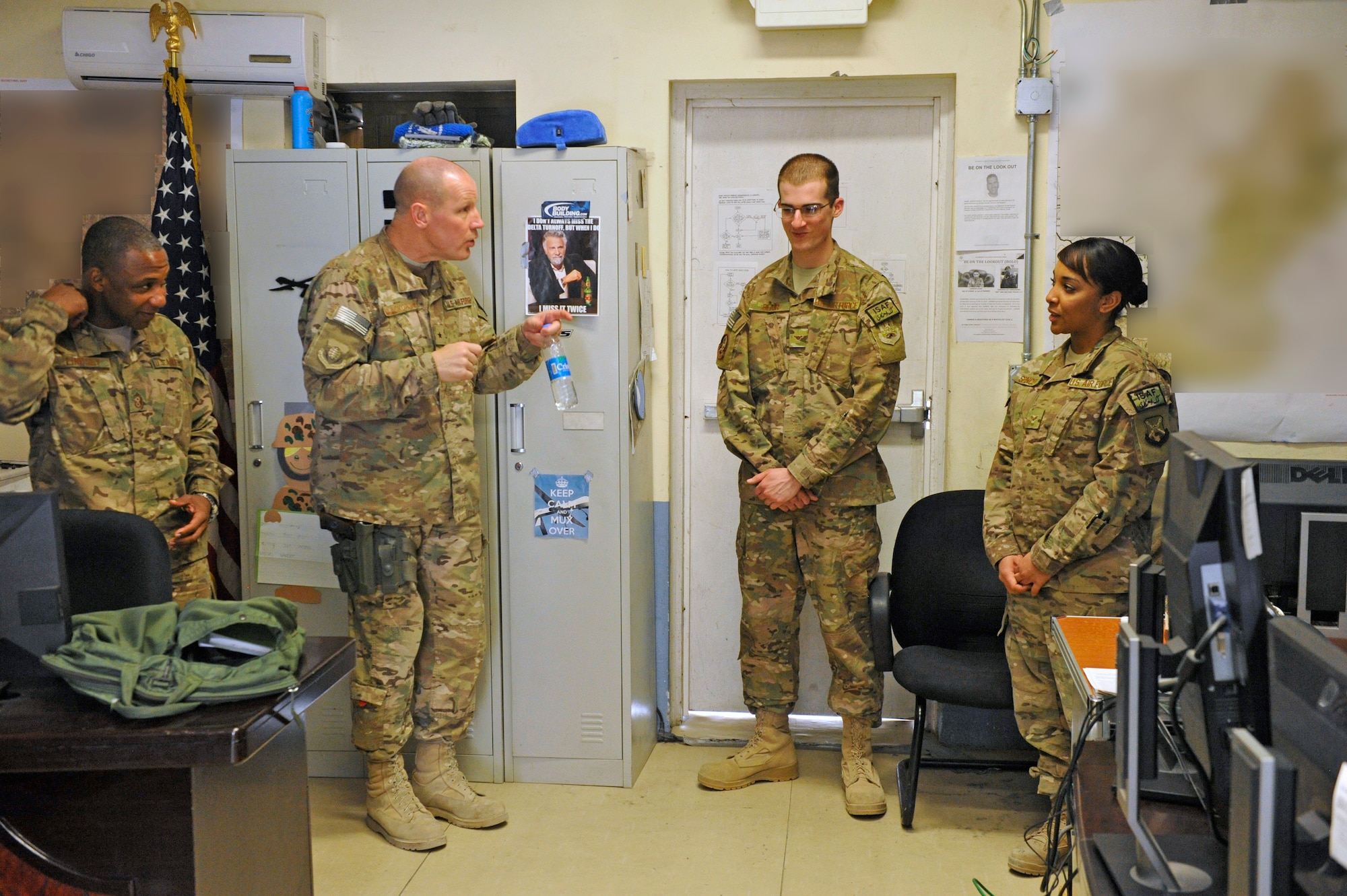 Brig. Gen. Patrick Malackowski, 455th Air Expeditionary Wing commander, talks to Airman 1st Class Max Blair and Senior Airman Angela Spencer during a visit to Jalalabad Airfield, Afghanistan, Feb. 25, 2014. Malackowski spent the day talking to airmen at Jalalabad and recognizing outstanding performers there.(U.S. Air Force photo by Senior Master Sgt. Gary J. Rihn/Released)(Maps were blurred for security reasons)