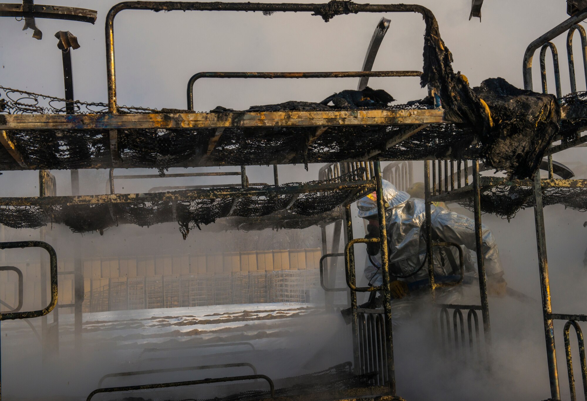 Firefighters from the 376th Expeditionary Civil Engineer Squadron enter the interior of a smoldering tent to put out any remaining fires during the training event at Transit Center at Manas, Kyrgyzstan, March 1, 2014. The 376th ECES used the training to demonstrate how fast the tents burn: In this case, approximately two and a half minutes. (U.S. Air Force photo/Staff Sgt. Travis Edwards)