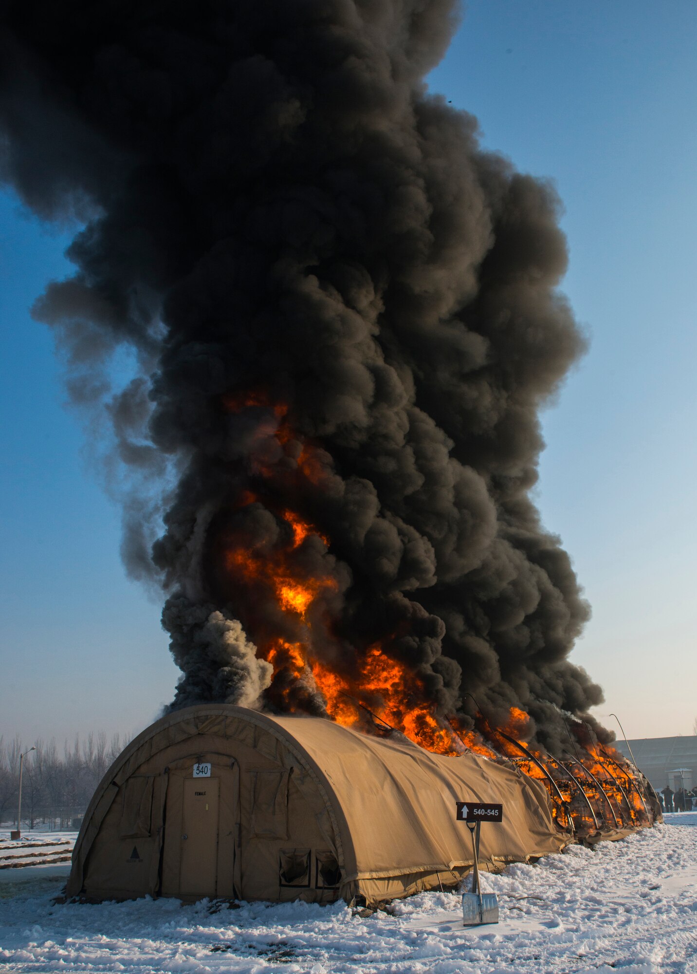 Flames burst through the top of a tent during a controlled-fire training event at Transit Center at Manas, Kyrgyzstan, March 1, 2014. The 376th ECES used the training to demonstrate how fast the tents burn: In this case, approximately two and a half minutes. The transient tent was the last in Hotel Alaska, marking another step in closing the facility and removing U.S. troops from the Transit Center by July 11, 2014. (U.S. Air Force photo/Staff Sgt. Travis Edwards) 