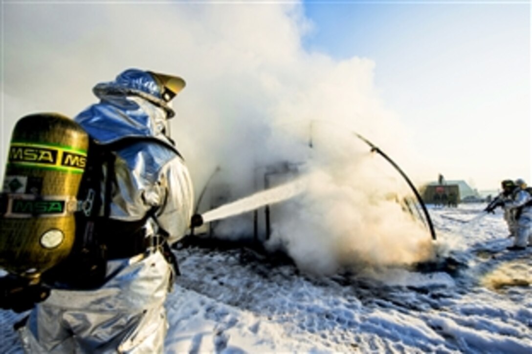 Firefighters extinguish a fire during a training event at the Transit Center in Manas, Kyrgyzstan, March 1, 2014. The firefighters, assigned to the 376th Expeditionary Civil Engineer Squadron, demonstrated that a tent burns in about two and a half minutes.